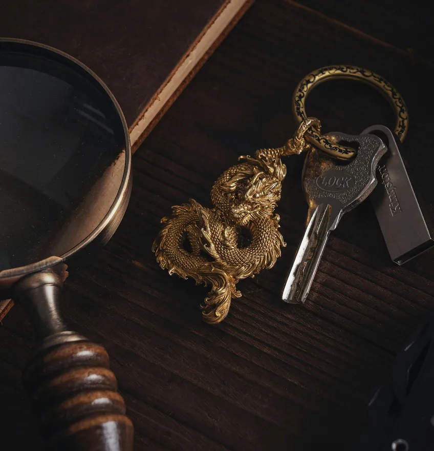 Keychain with dragon charm and keys on wooden table.