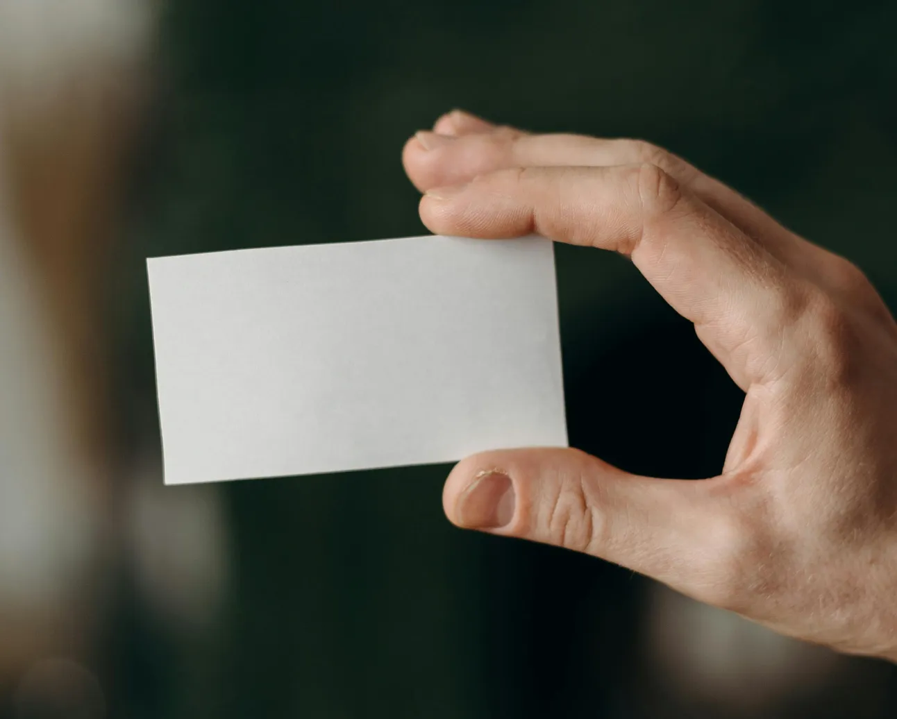 Hand holding a blank business card.