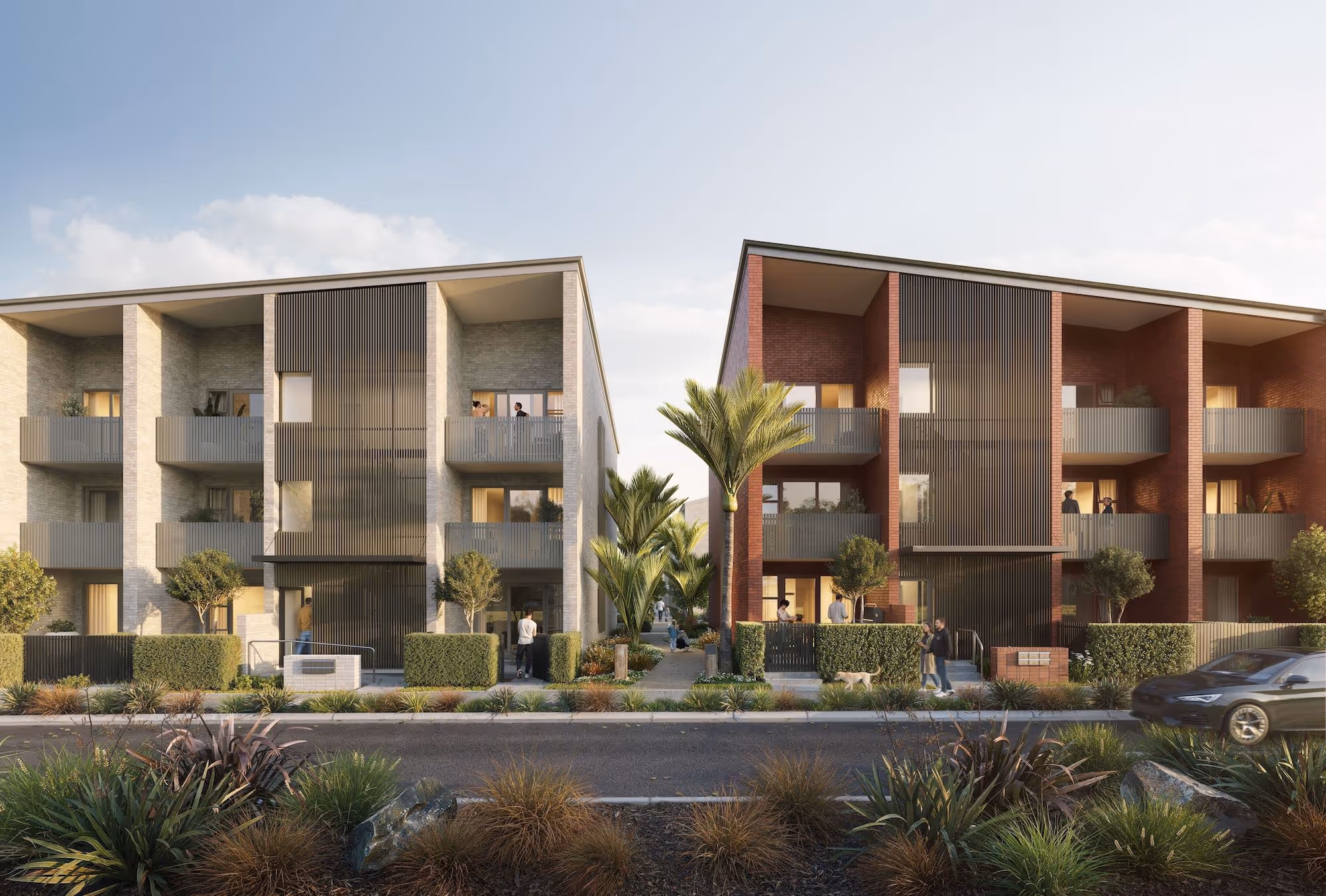 Modern three-story residential buildings with balconies, palm trees, and people walking and socializing in front.