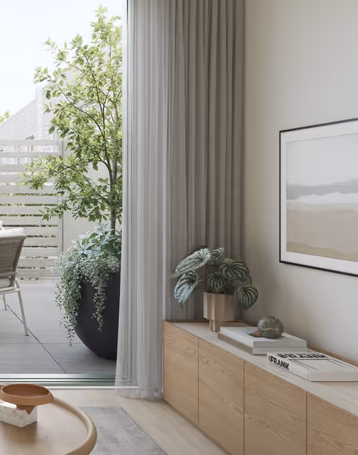 Modern indoor living space with wooden cabinet, potted plant, and large window opening to outdoor patio with greenery.