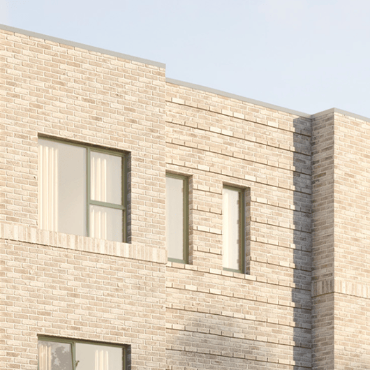 Light beige brick building corner with rectangular windows and sunlight casting shadows.
