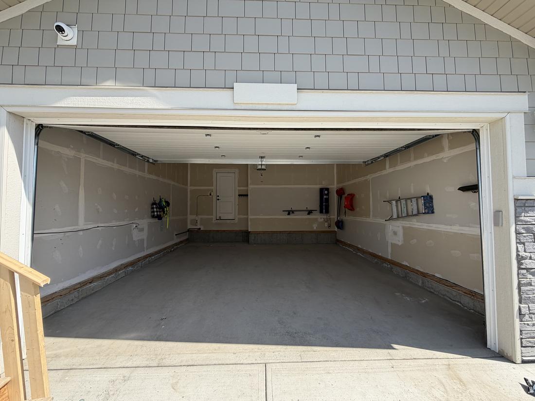 Bare cracked concrete garage floor in Alpine Calgary before epoxy coating