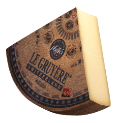 Quart de fromage Le Gruyère de Suisse avec croûte naturelle et texture lisse à l'intérieur.