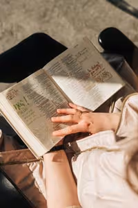 Medium closeup shot of a woman reading the Bible during a bible study. 