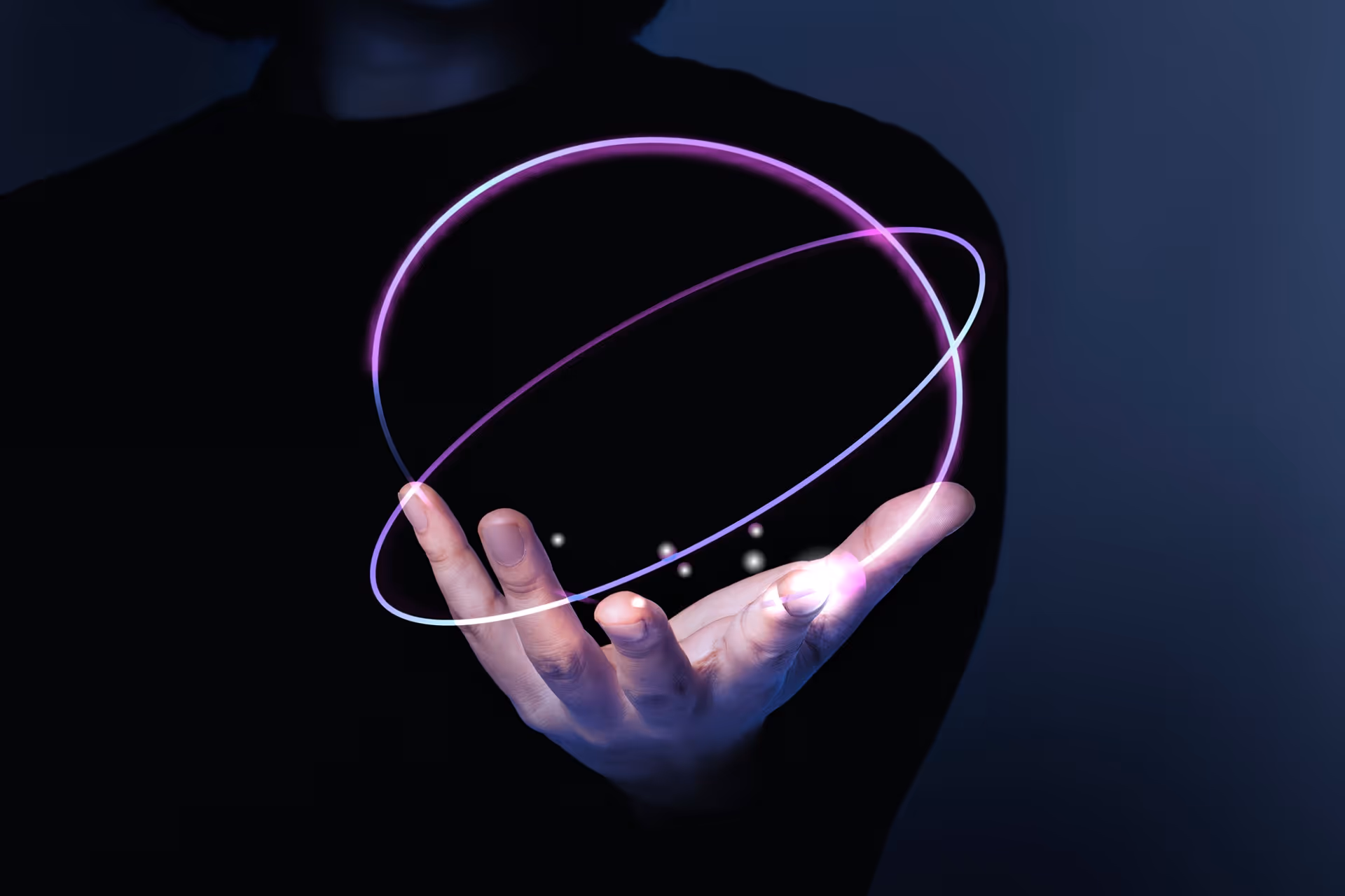 Hand with glowing purple and white orbital rings and small light orbs floating above the palm against a dark background.