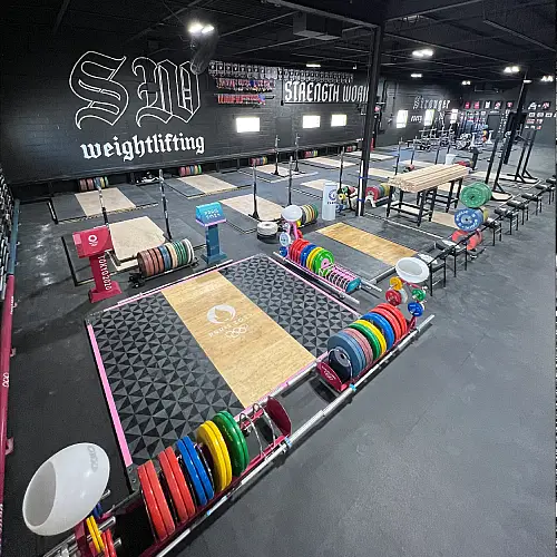 A spacious gym showcasing an array of weights and barbells for strength training.