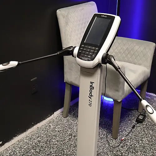 A phone on a stand positioned in front of a chair, showcasing a modern workspace setup.