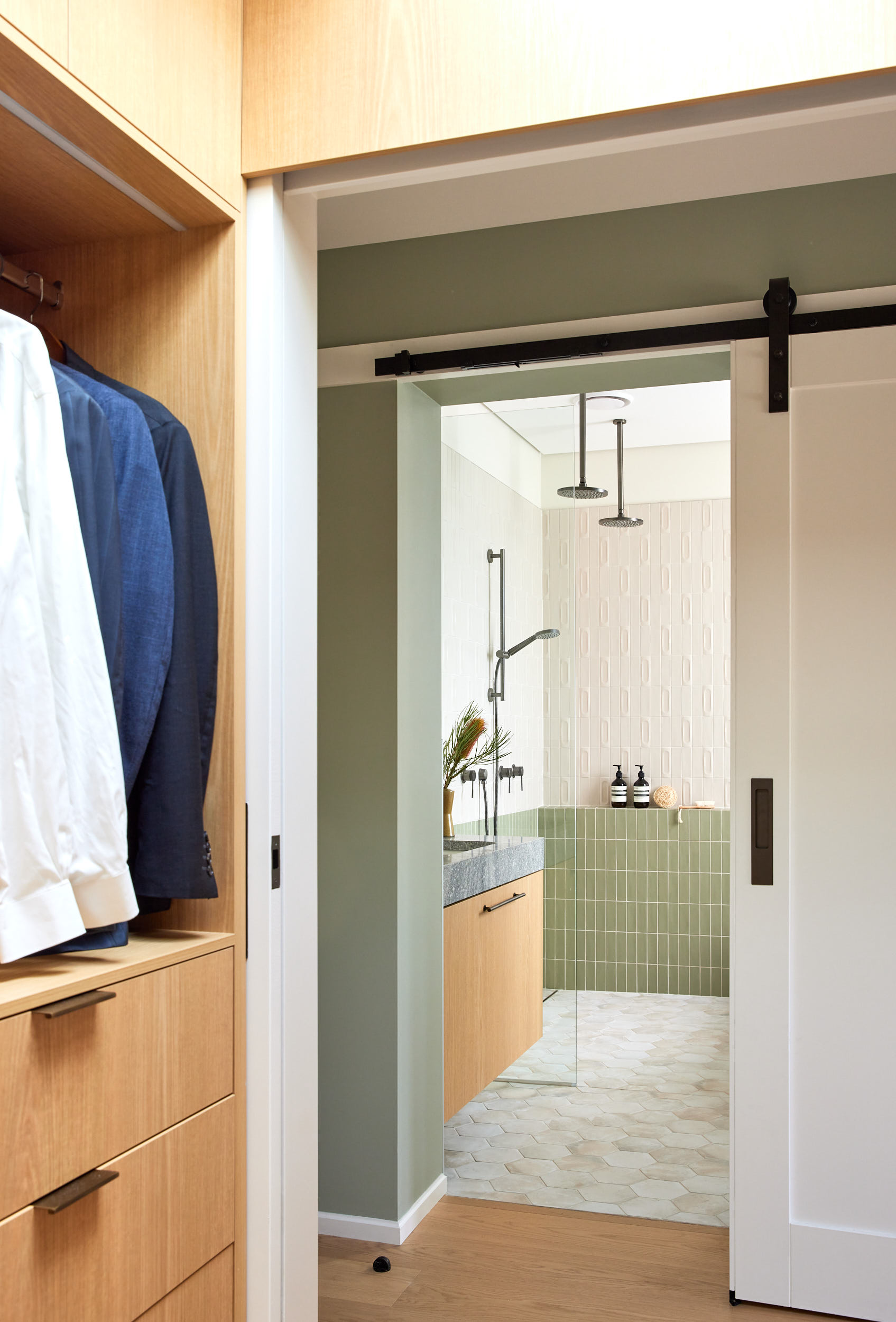 Minimalist kitchen sink with gold faucet and gold basin against a white patterned tile backsplash.