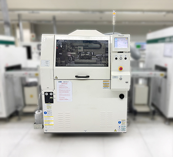 White SMT machine with display screen and control buttons in an electronics manufacturing setting.