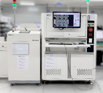 Industrial machine with computer screen showing detailed images, keyboard, and control panel in a clean room.