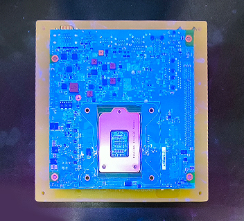 Blue circuit board with a central microchip mounted on a yellow base against a dark background.