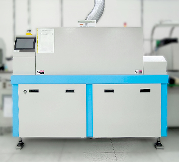 Industrial baking or curing machine with a silver hood and blue base in a clean workspace.