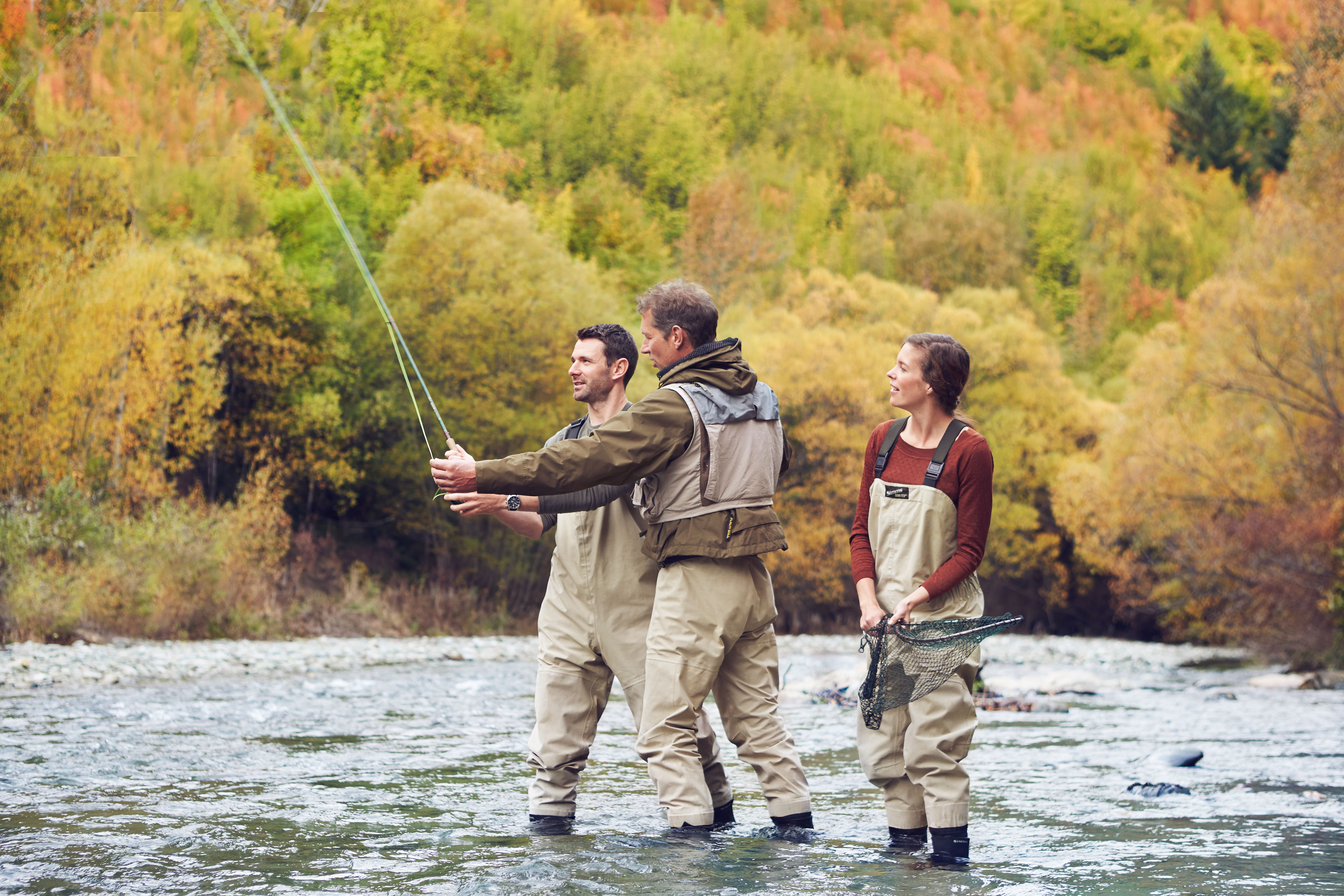 A serene coastal view featuring a rocky outcrop, gentle waves, and a vibrant sunset sky, framed by lush greenery.