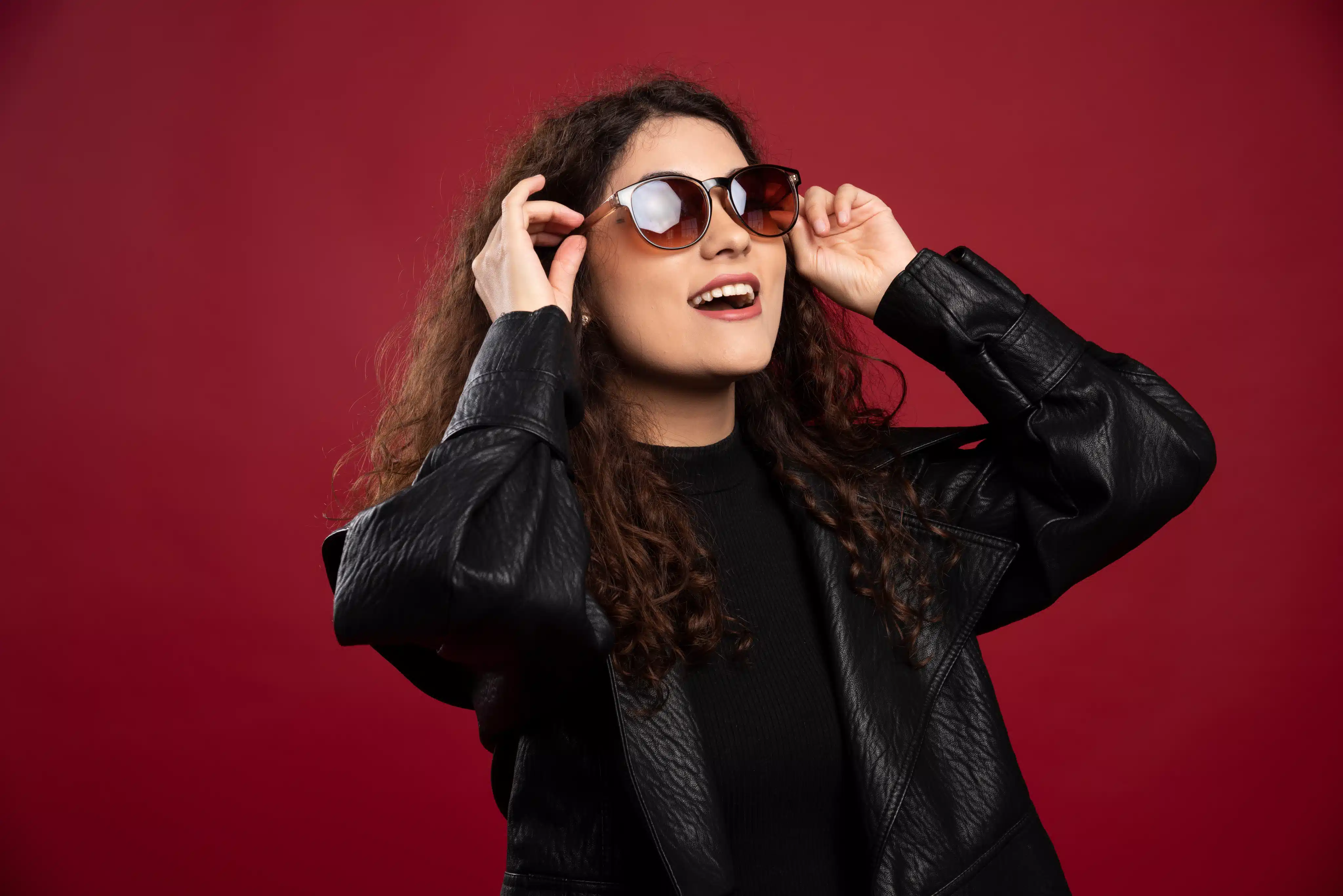 A beautiful woman with sunglass infront red background