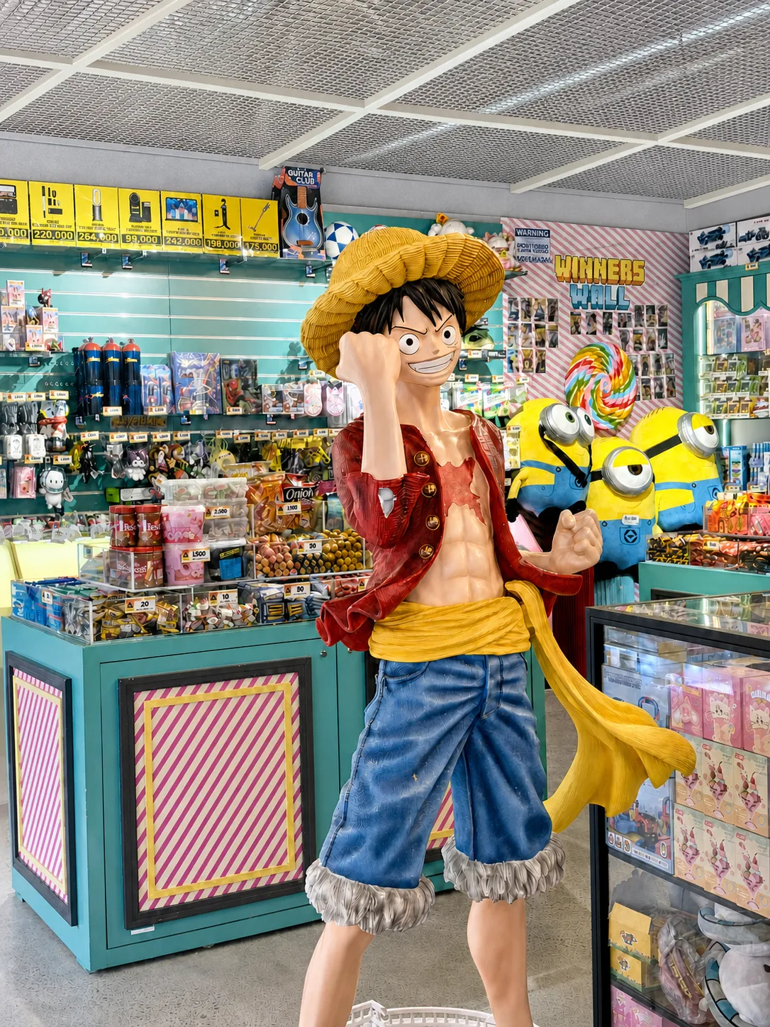 Prize redemption shop at KOKO Amusement with display shelves and a large character statue