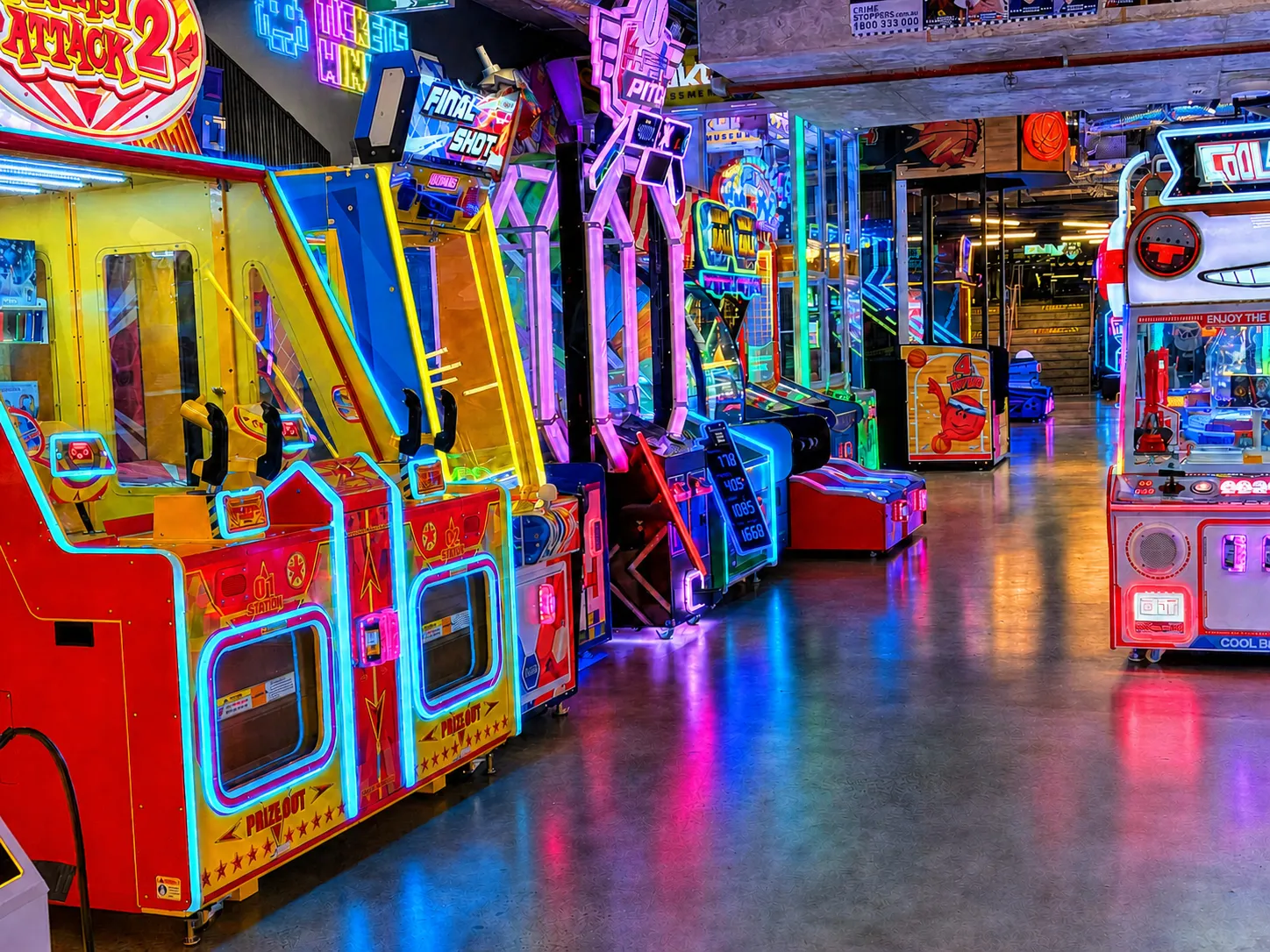 Aisle of brightly lit ticket and prize arcade machines at KOKO Amusement