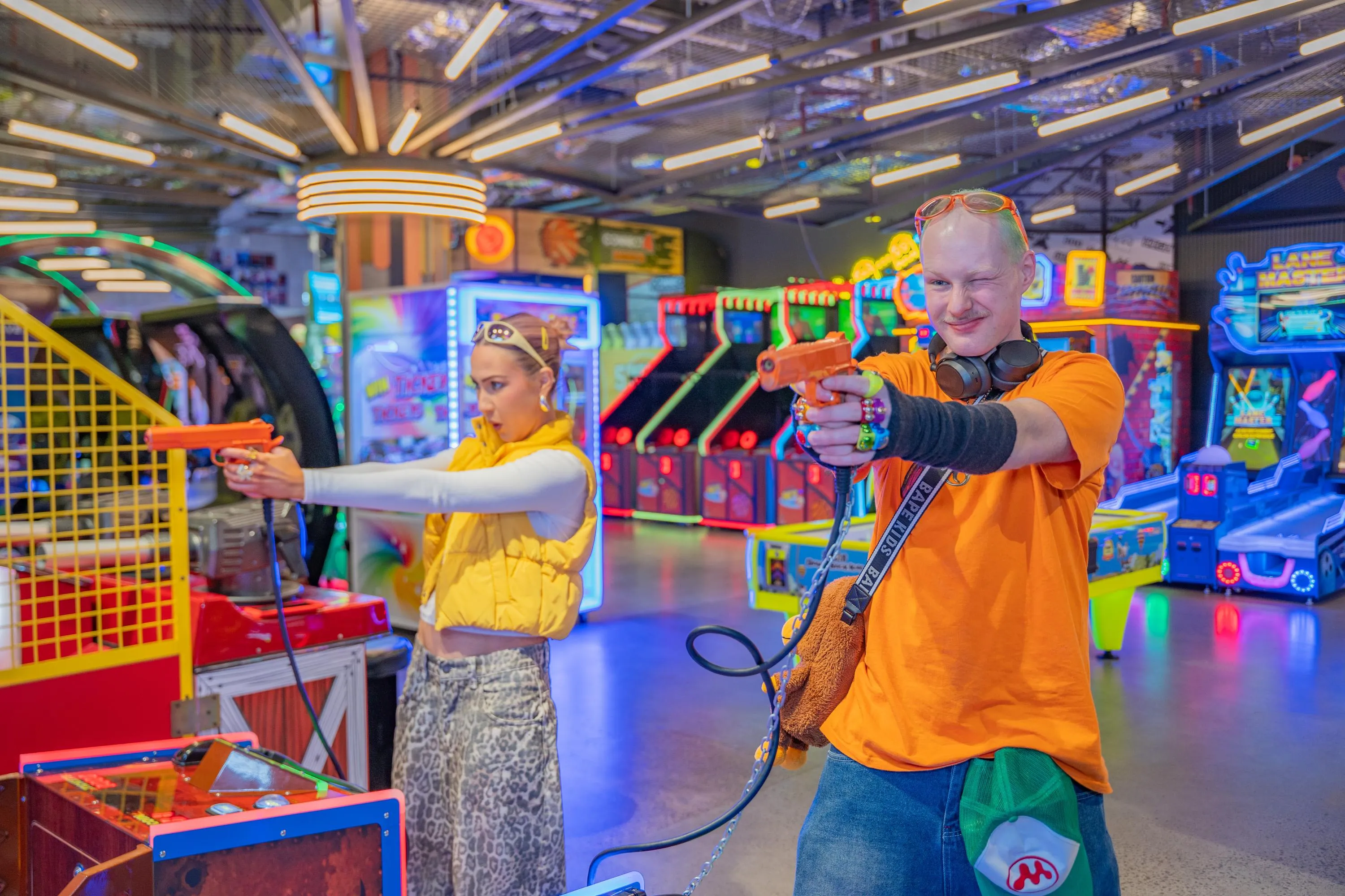 Two adults playing a light gun shooting arcade game at KOKO Amusement