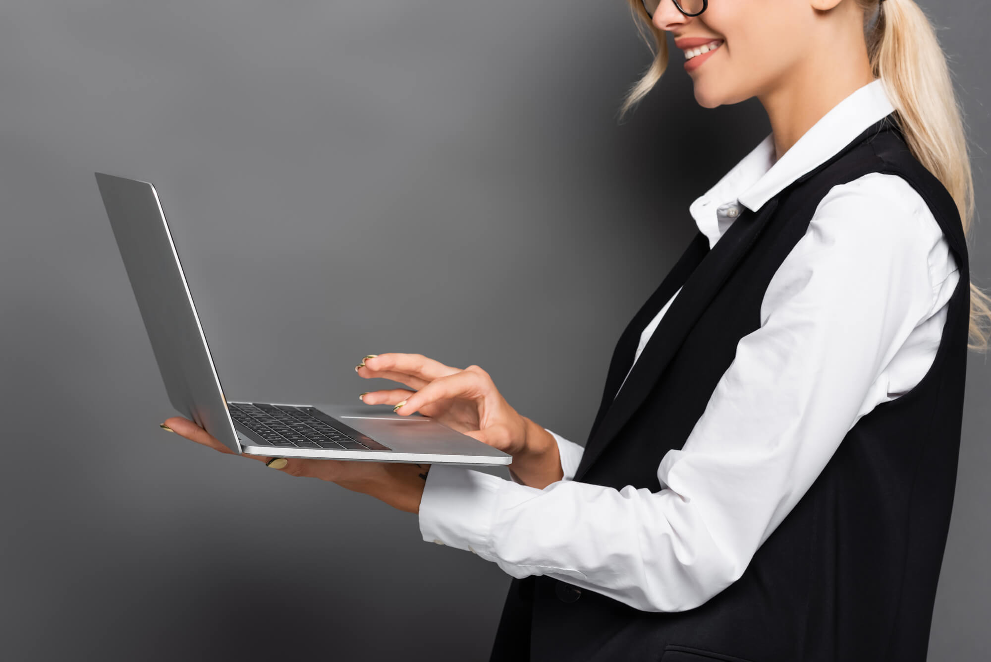 young professional woman happily looking at her laptop