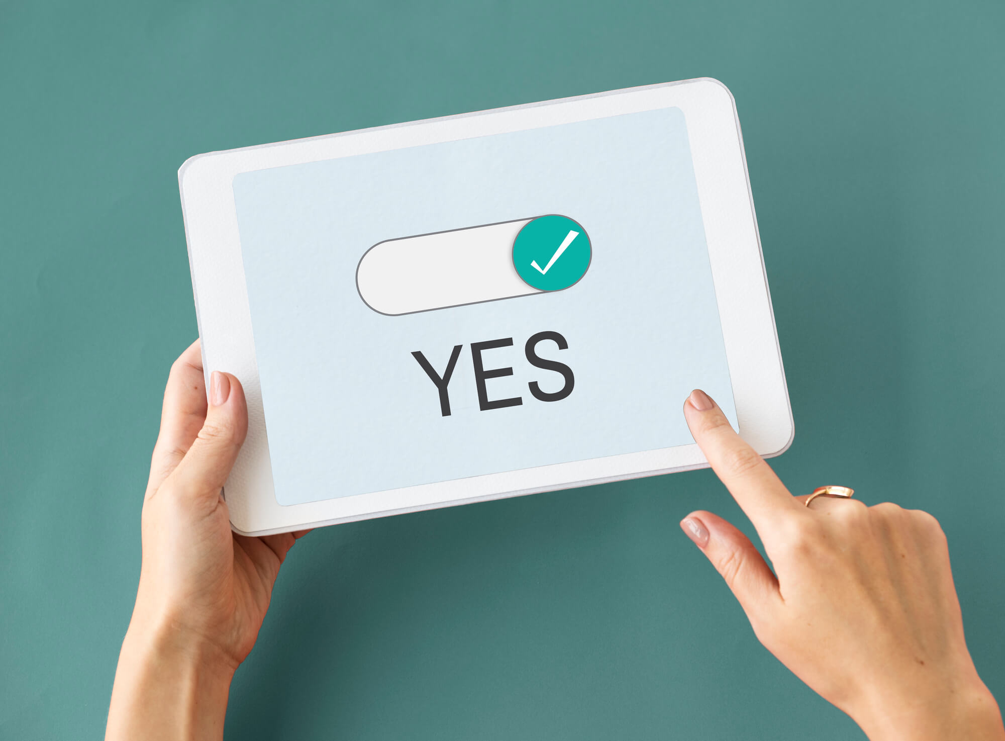 hand holding tablet with word yes