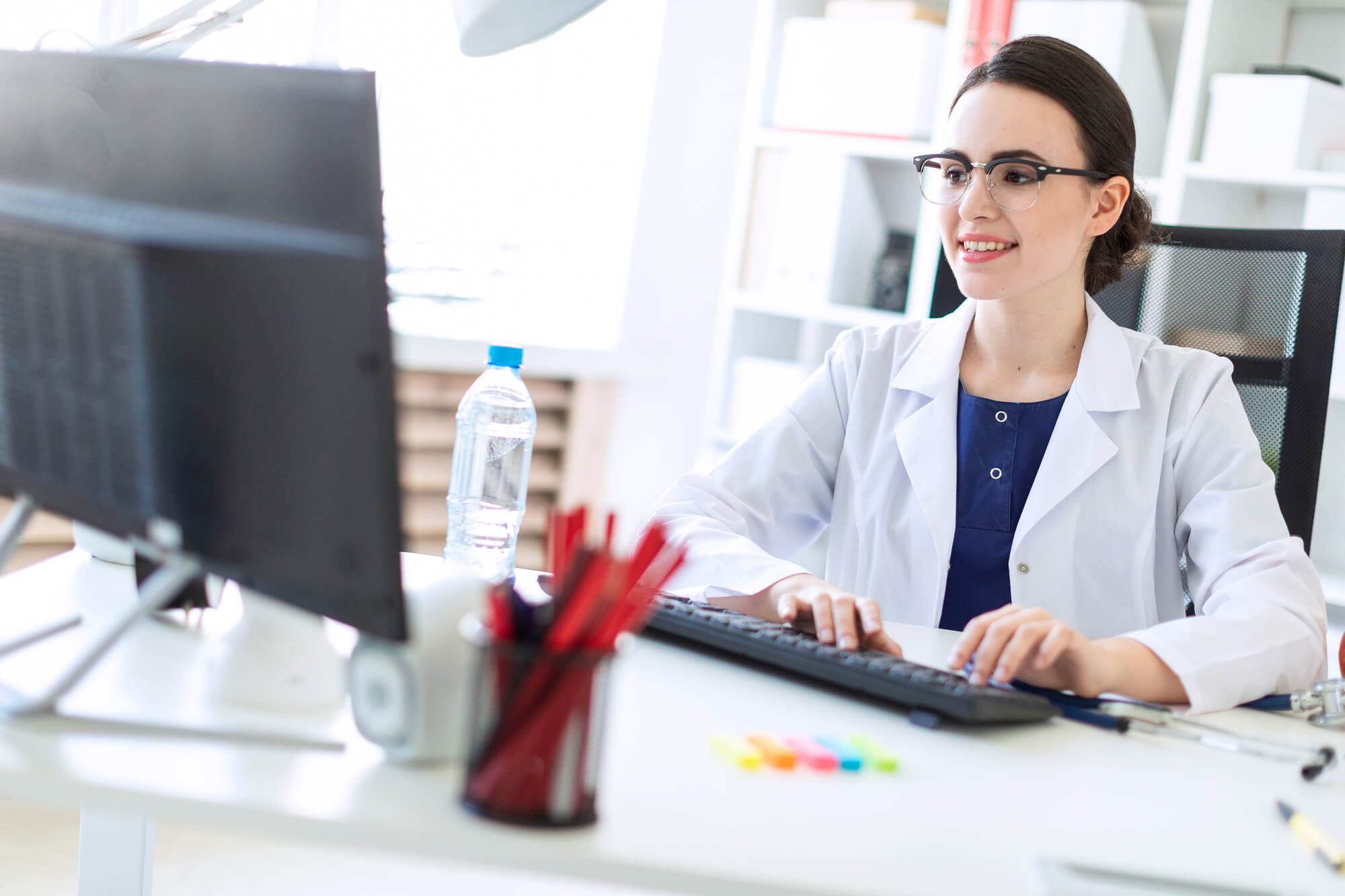 female dentist typing happily on computer
