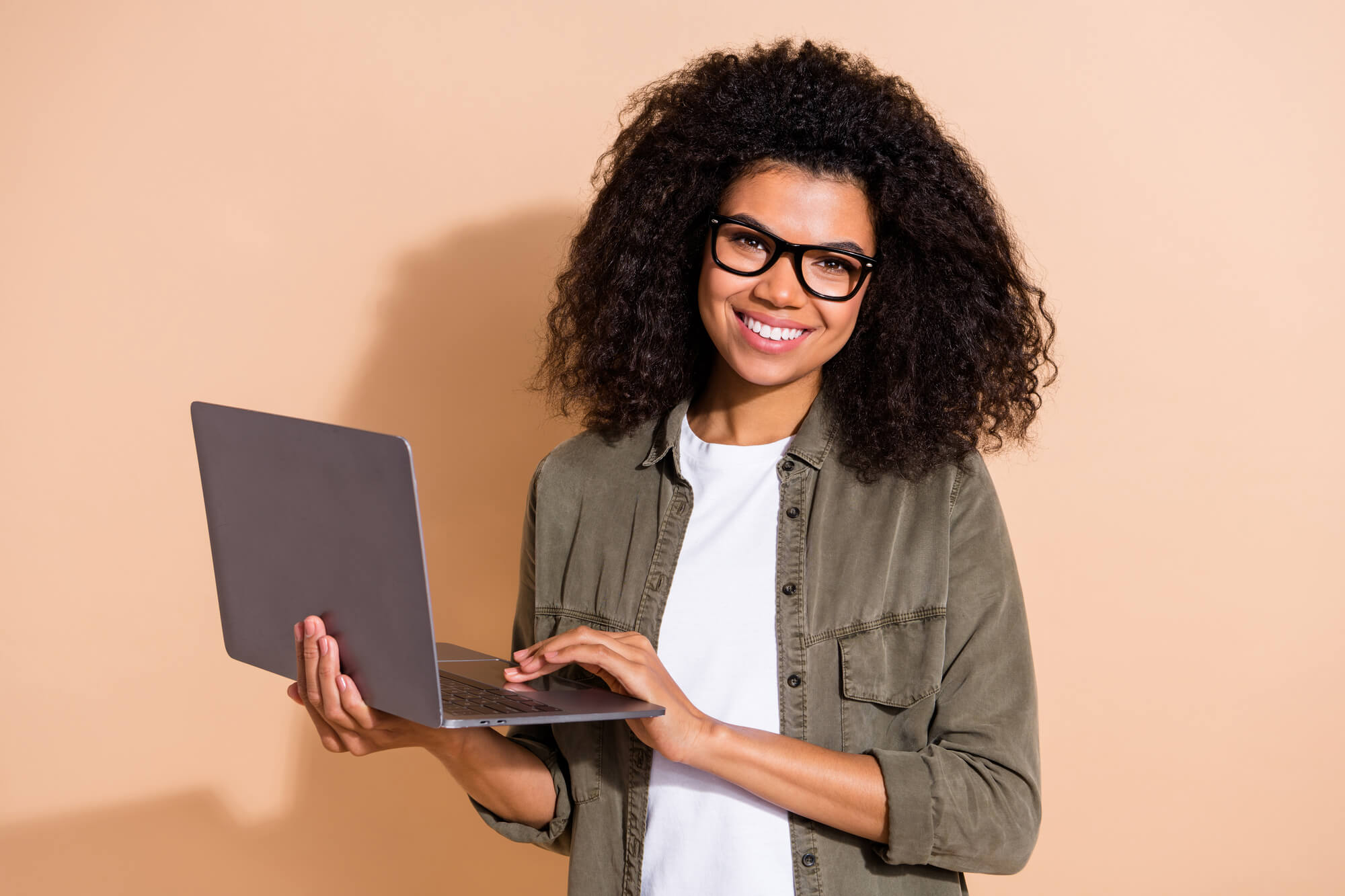 female marketer holding her laptop and posing