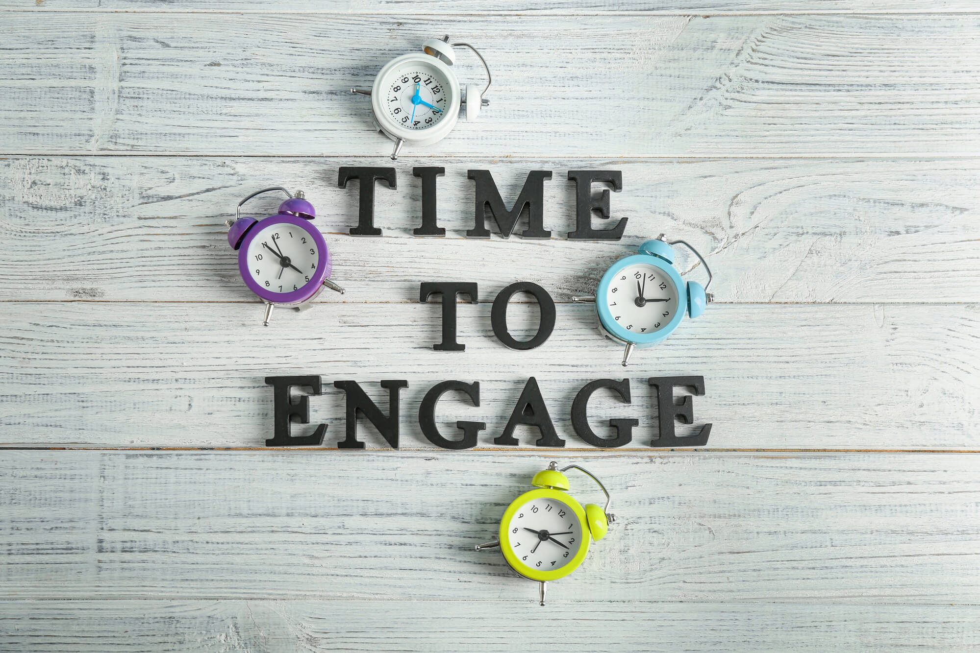 time to engage phrase and clocks on wooden surface