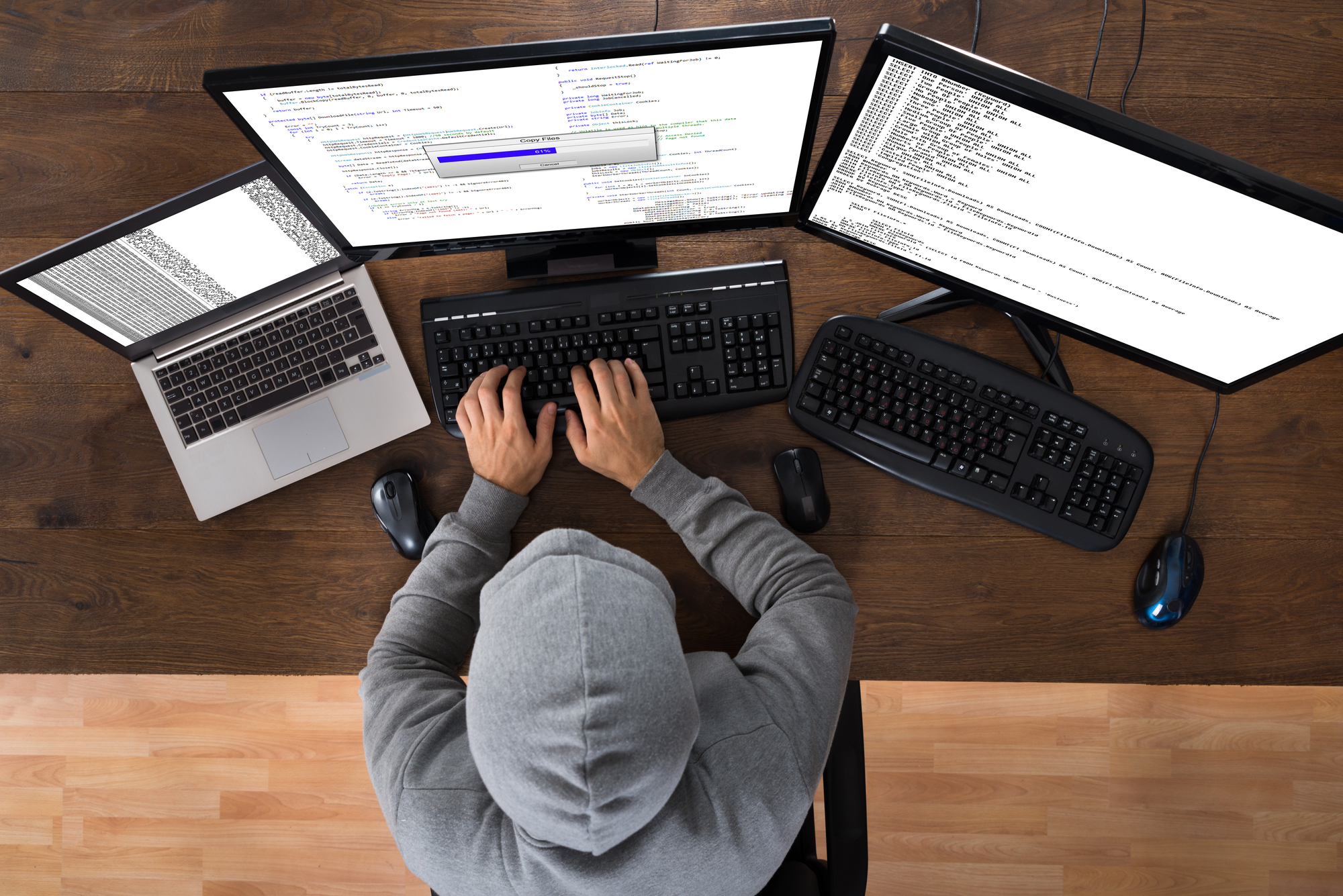 a hacker using multiple screens