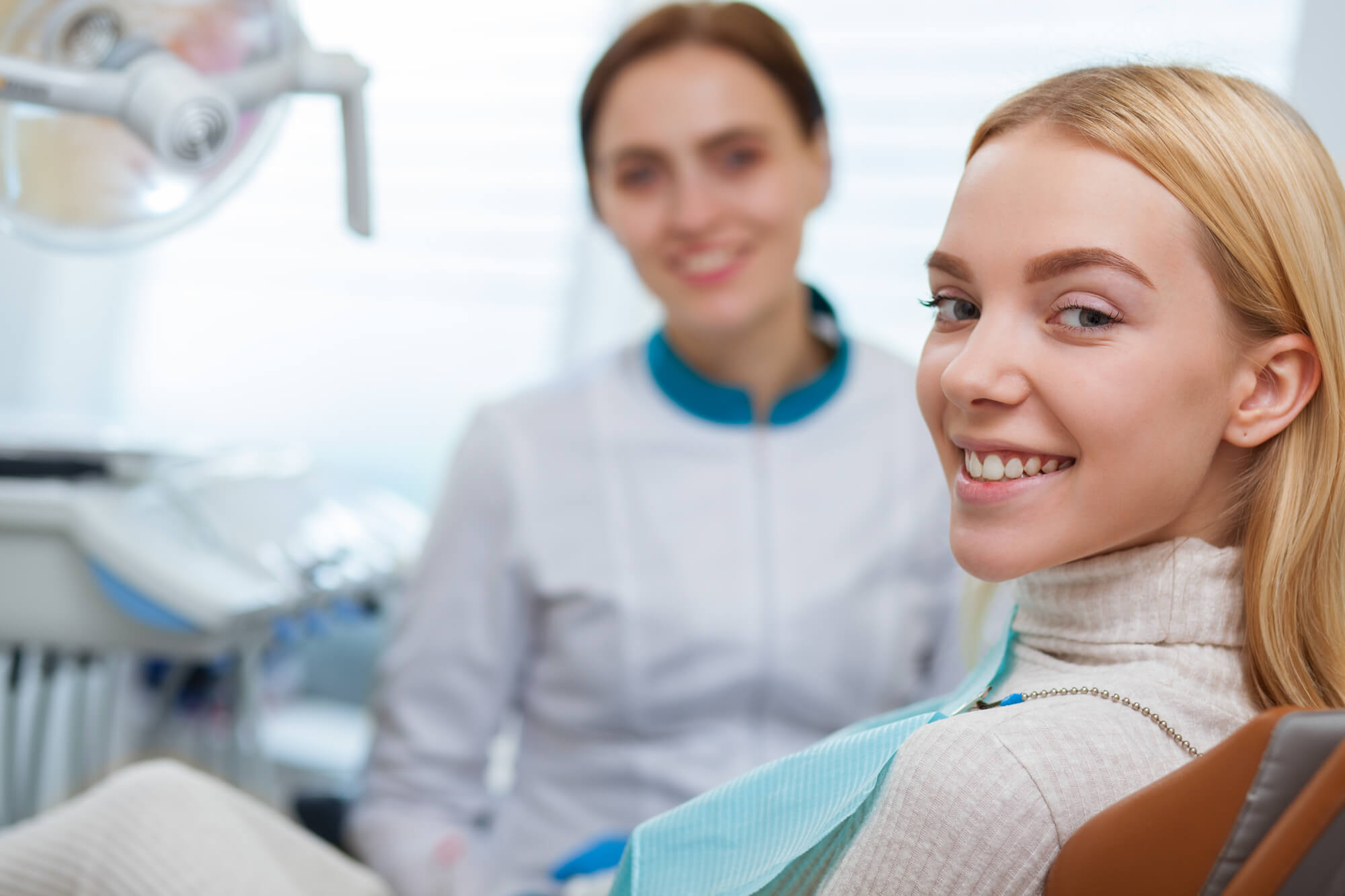 dentist and patient smiling at the camera