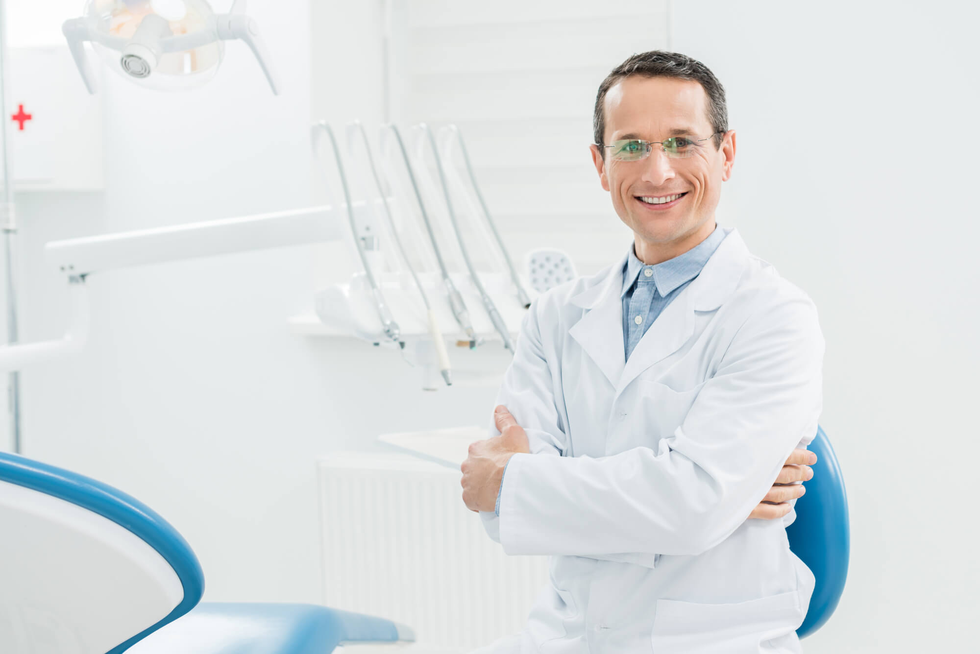 male dentist smiling and crossing his arms