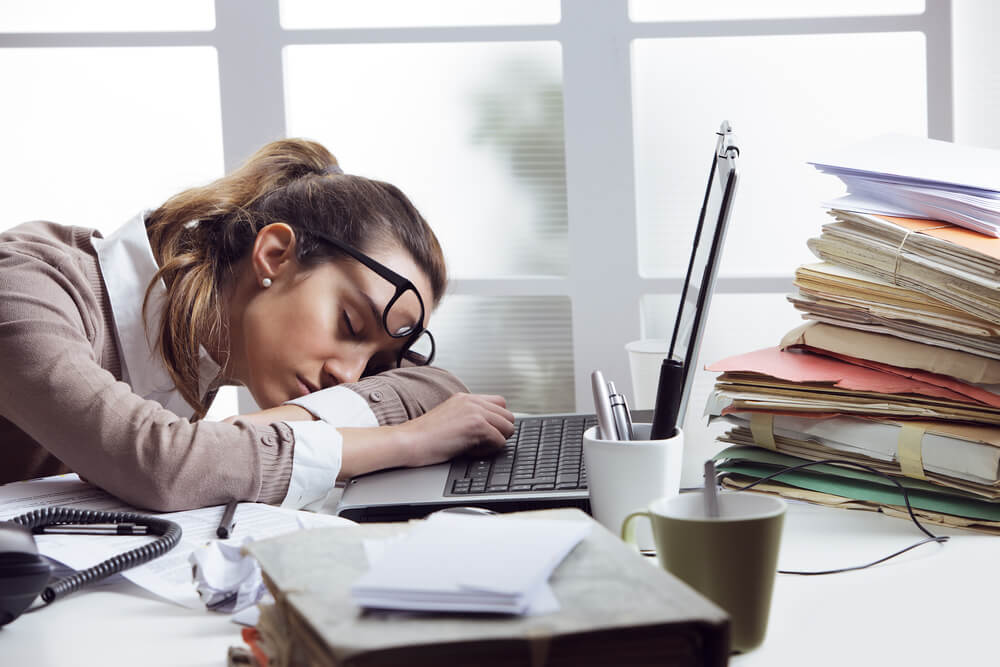 Business woman fell asleep on desk while working.