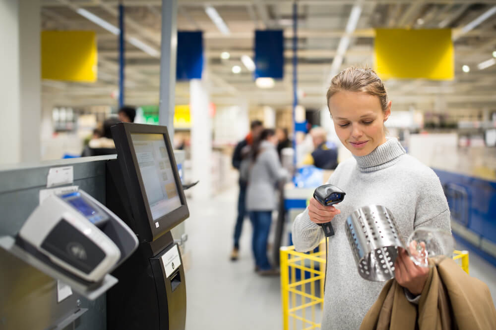 Holiday shopper scanning her own goods for checkout.