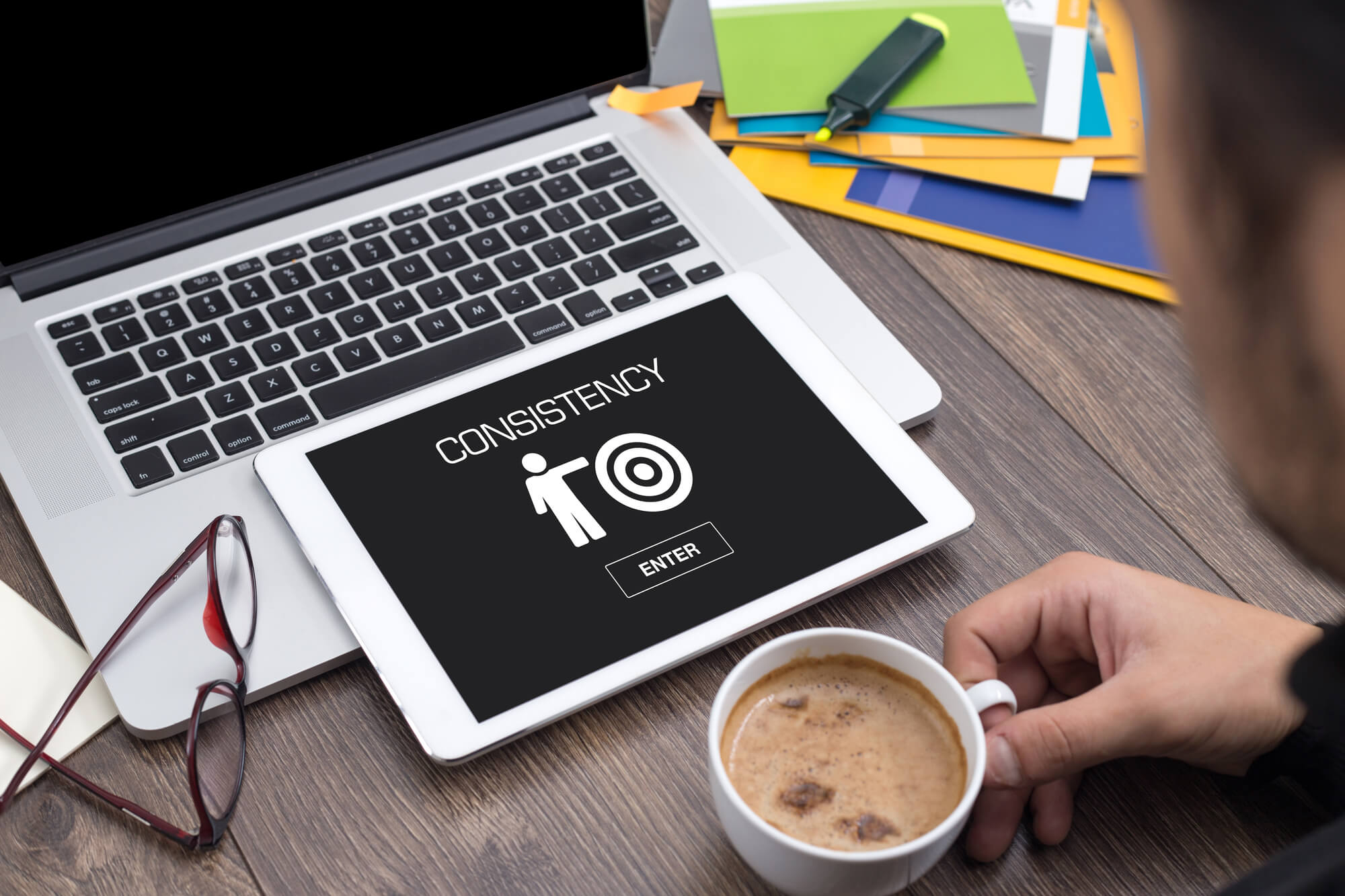 marketer looking at ipad screen with consistency word 