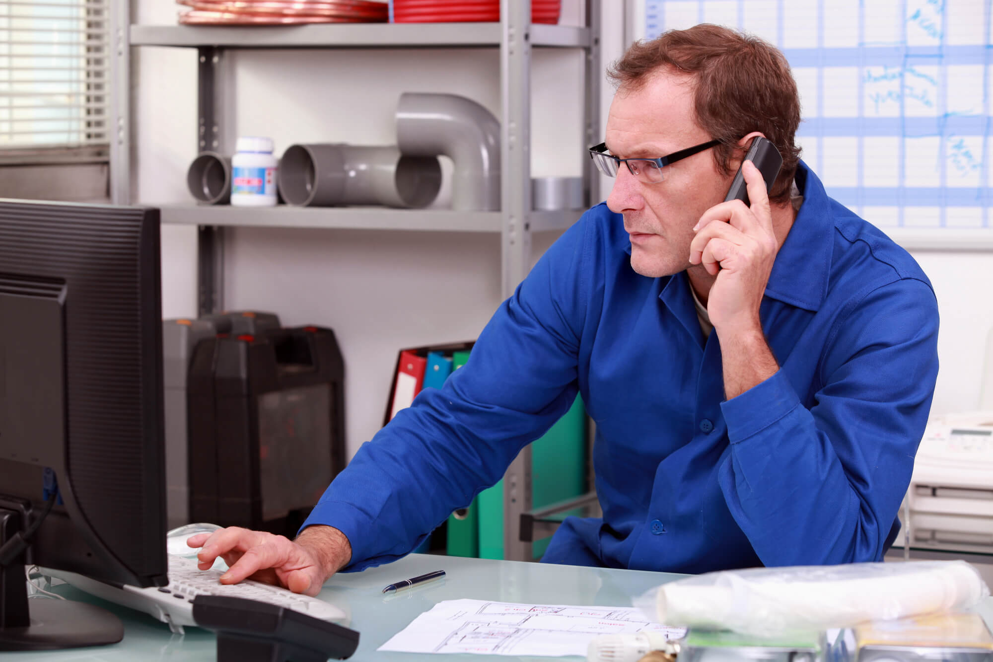 plumber making calls in front of the computer
