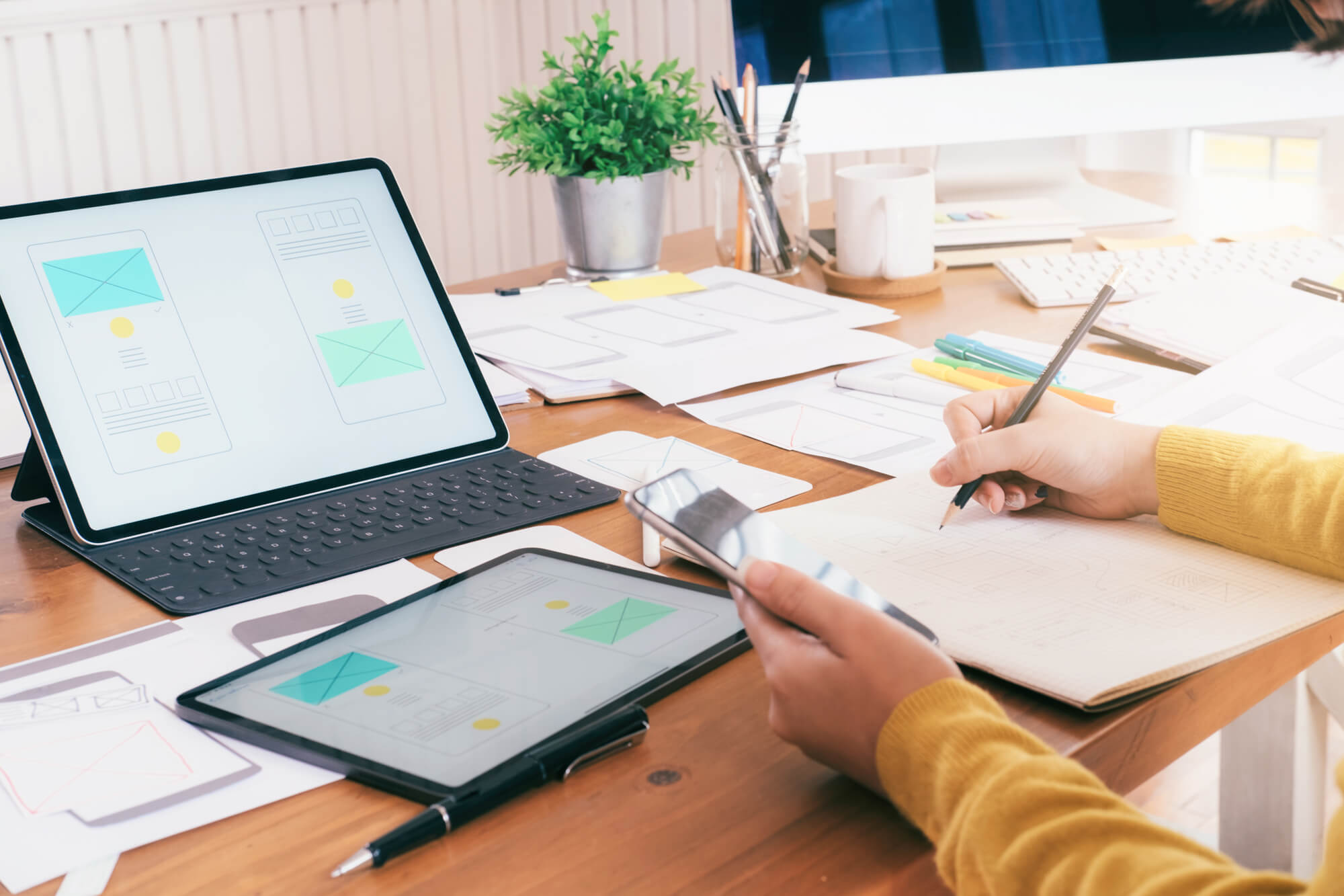 person writing while holding phone internet marketing