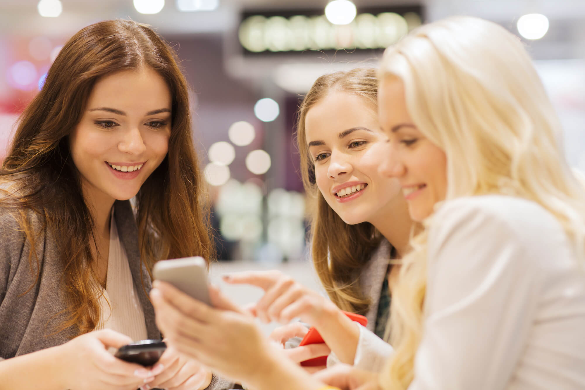 Three girls shopping on their phone
