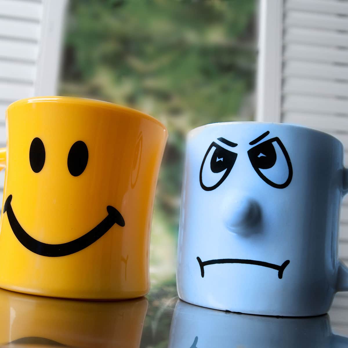 two mugs with opposite expressions