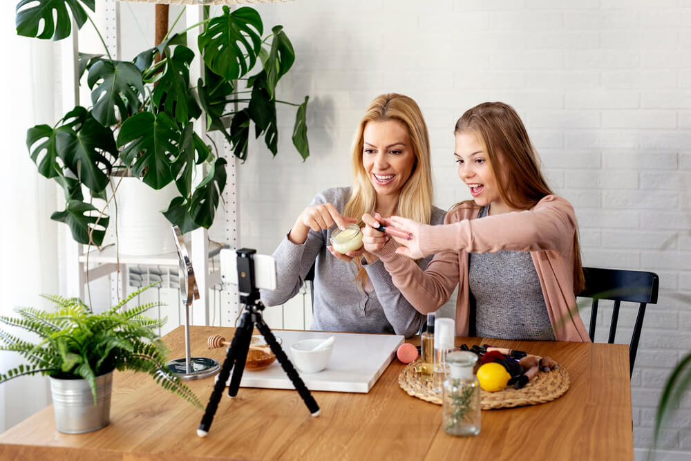 two girls taking a photo of their favorite product and posting it on social media