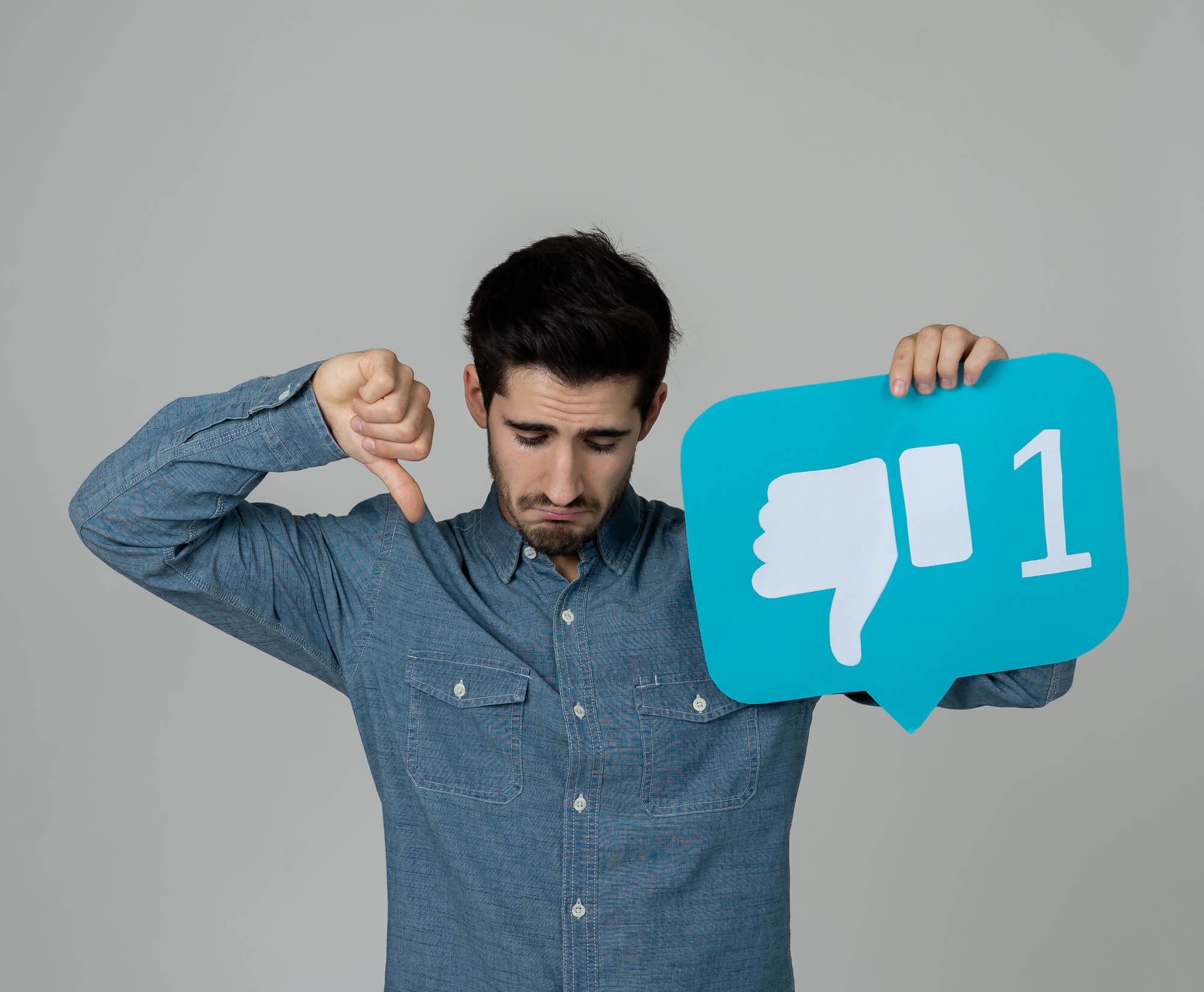 sad man holding a dislike card