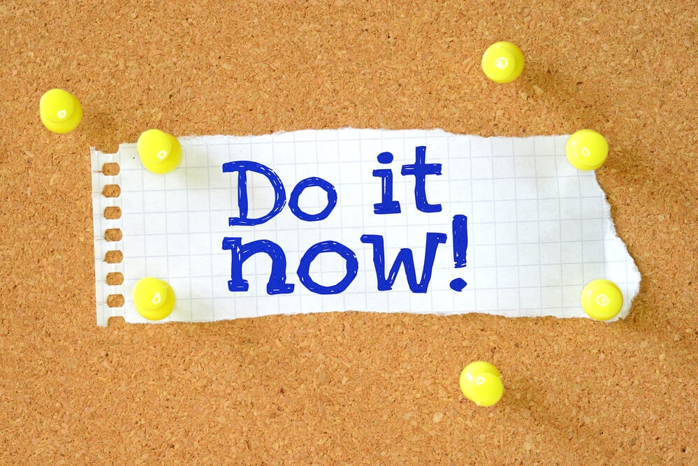 the phrase "do it now" written on a piece of paper