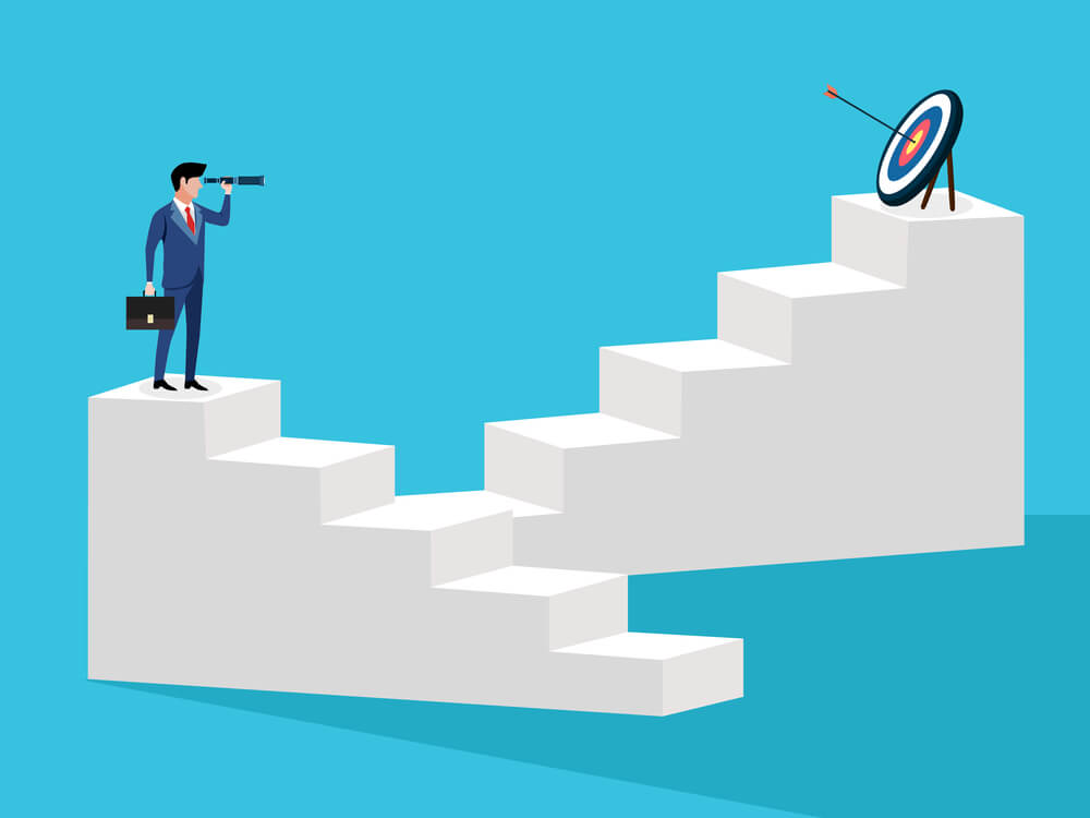 a business man looking at a goal through a telescope