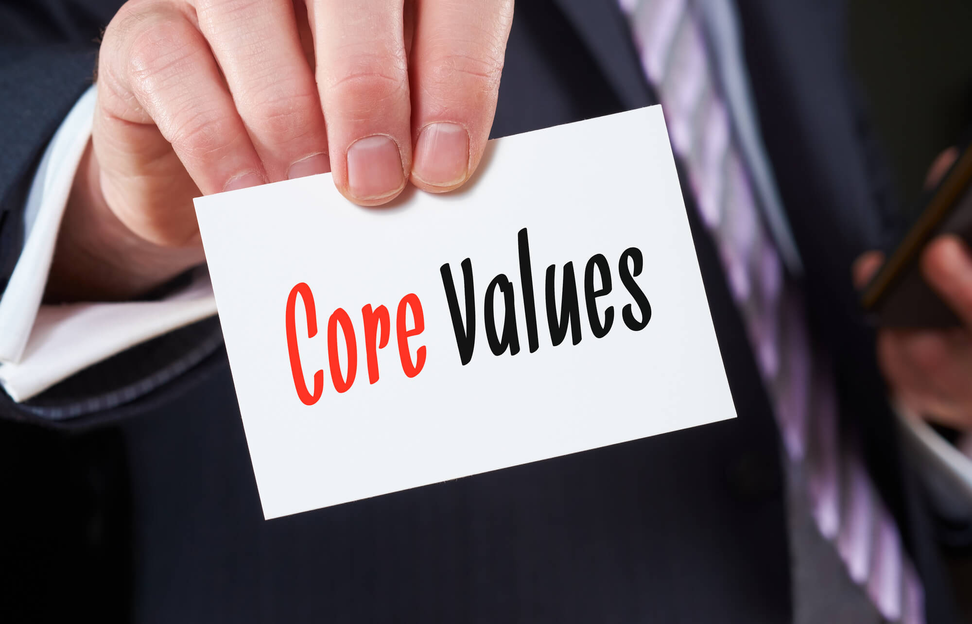 businessman holding core values card