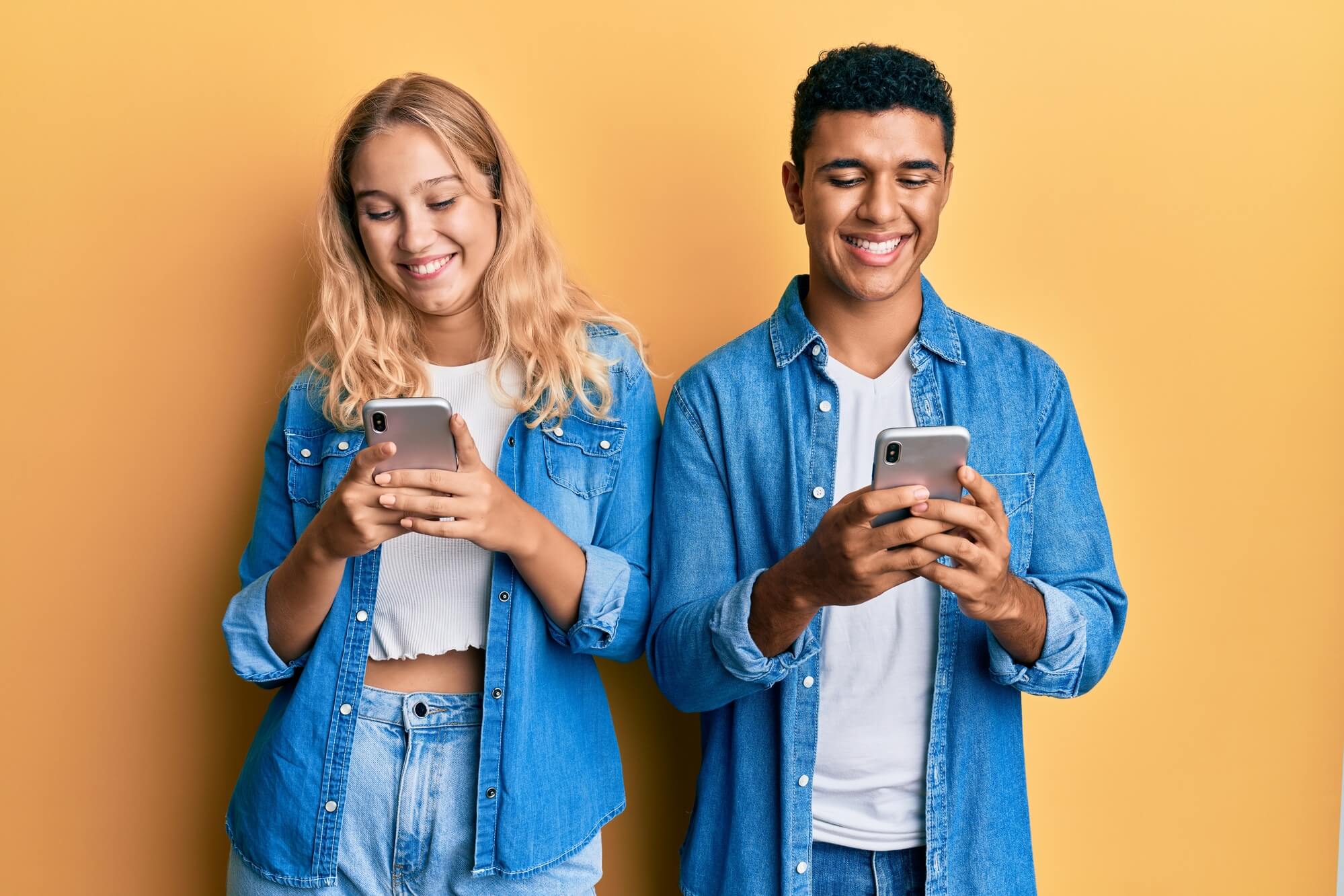 female and male looking at their phones with enthusiasm 