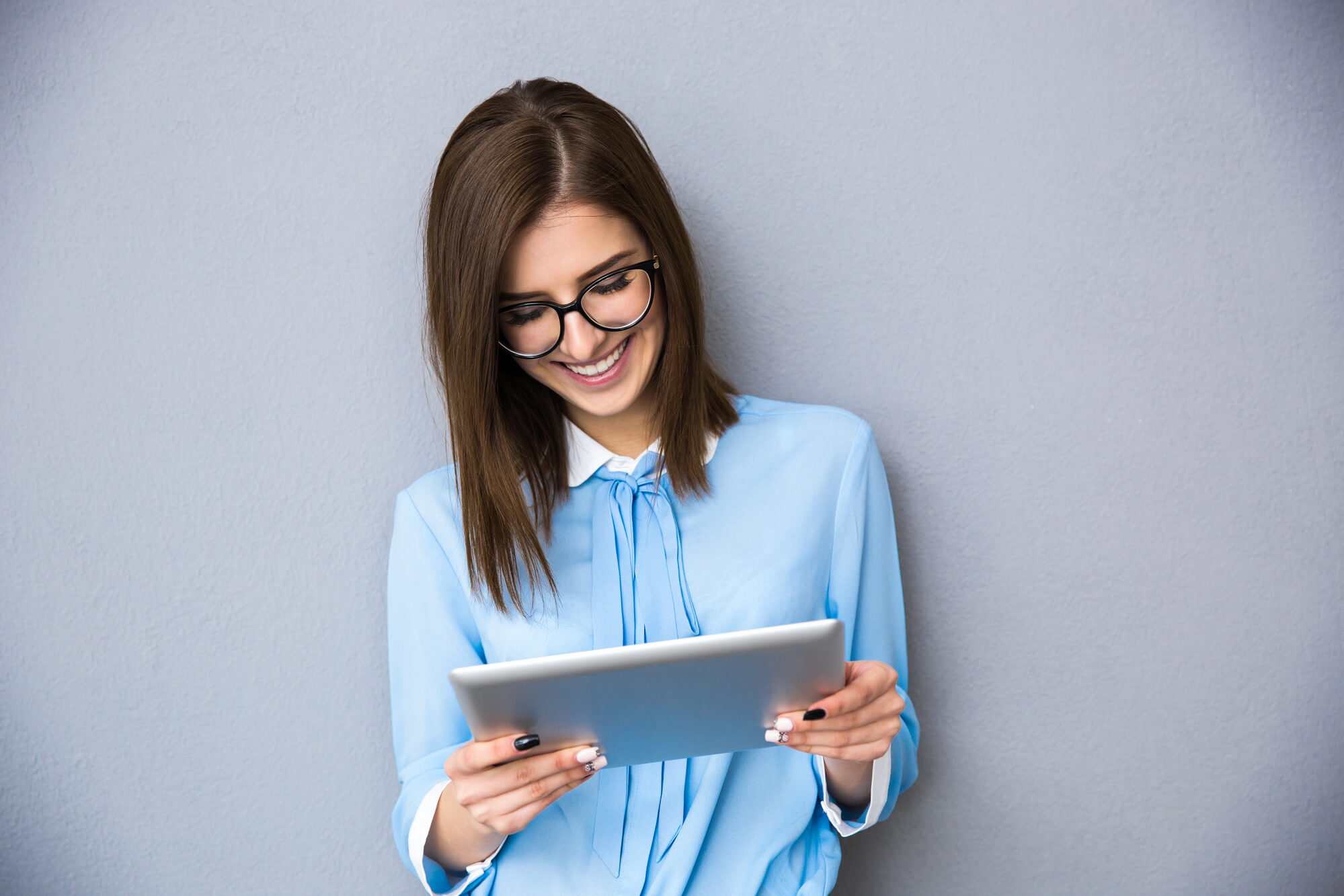 businesswoman looking at her tablet with a big smile on her face