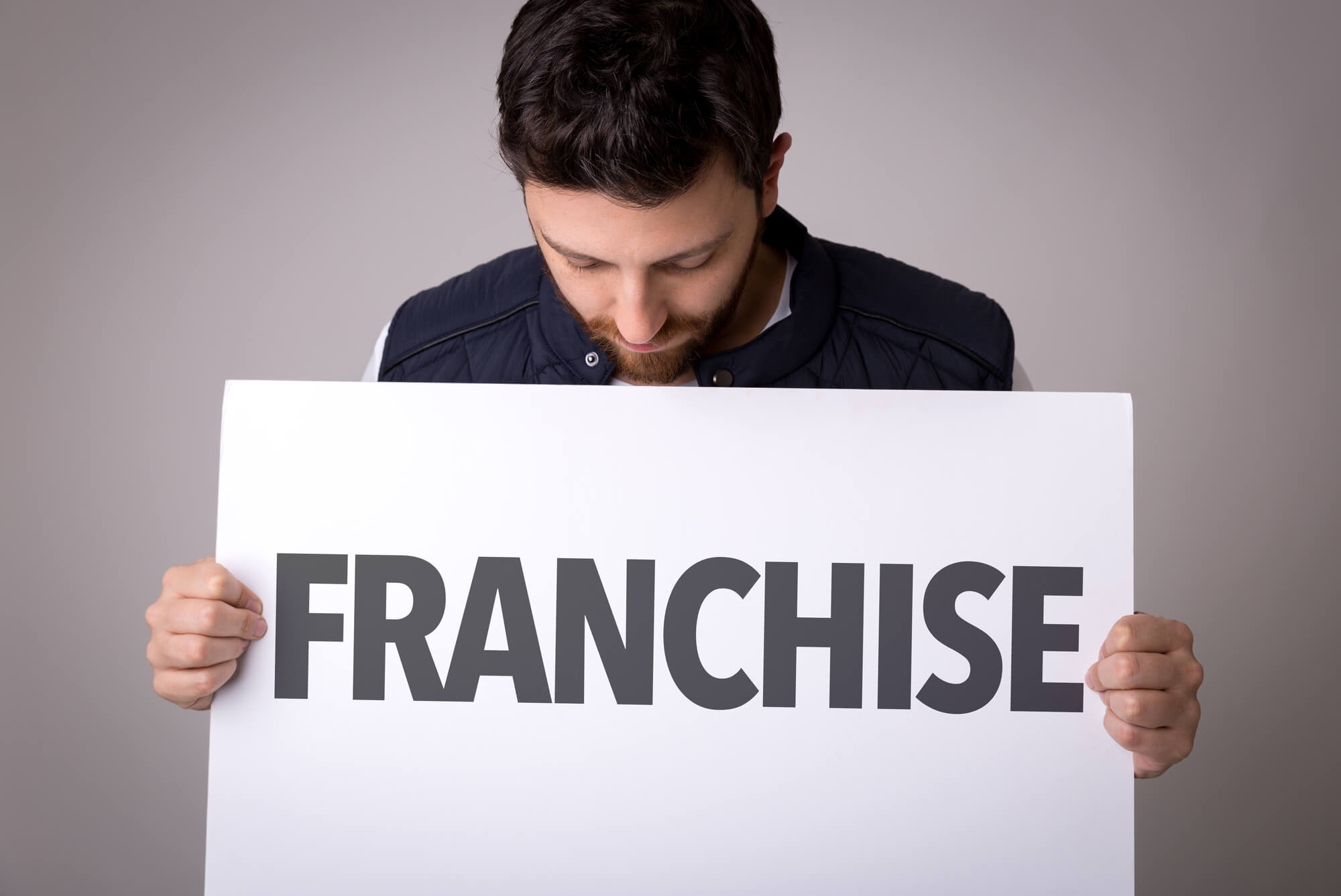 man holding a sign that says franchise