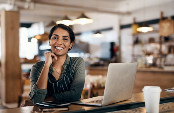 franchise owner posing happily with her laptop