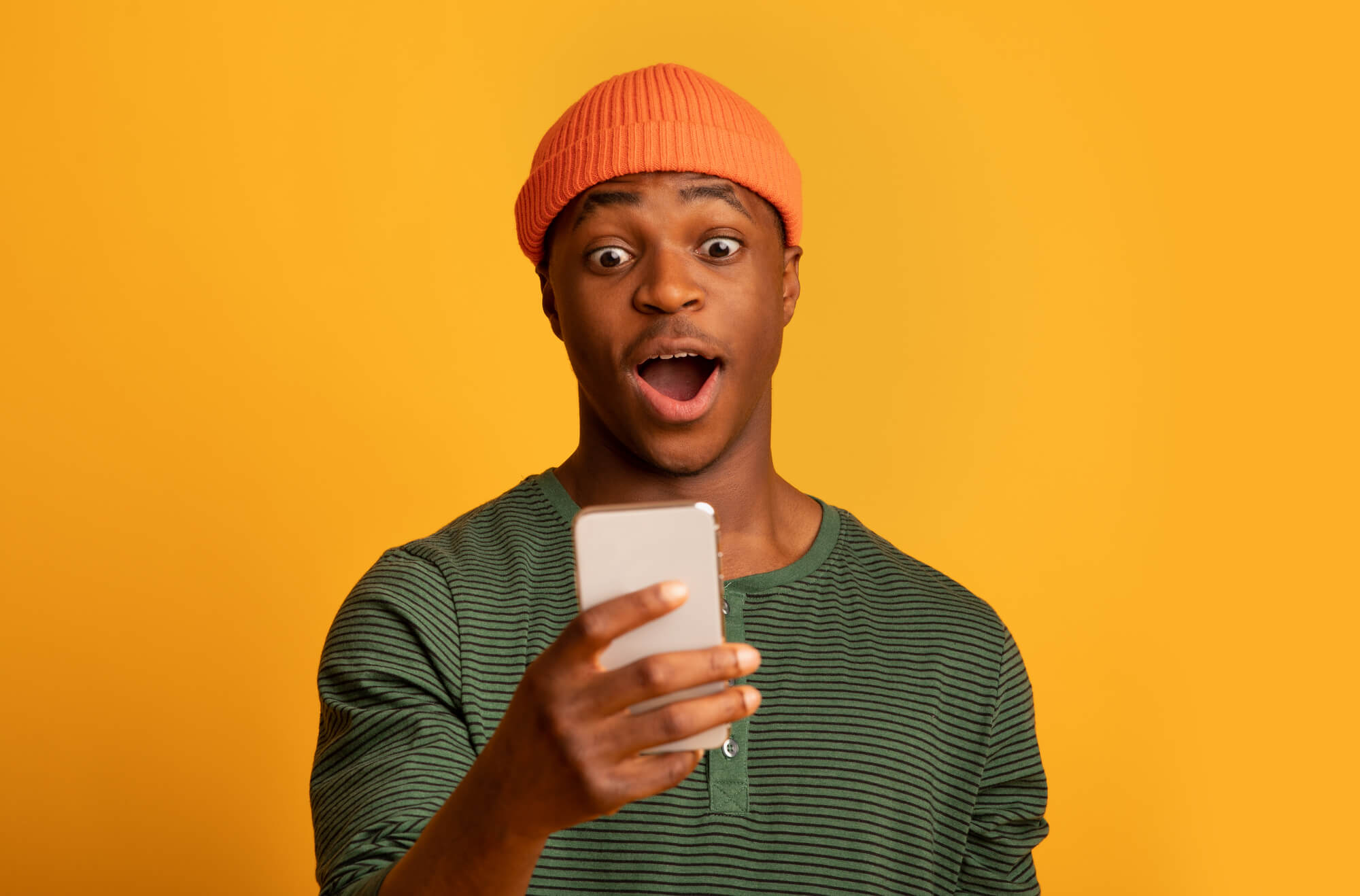 black man looking excitedly at phone