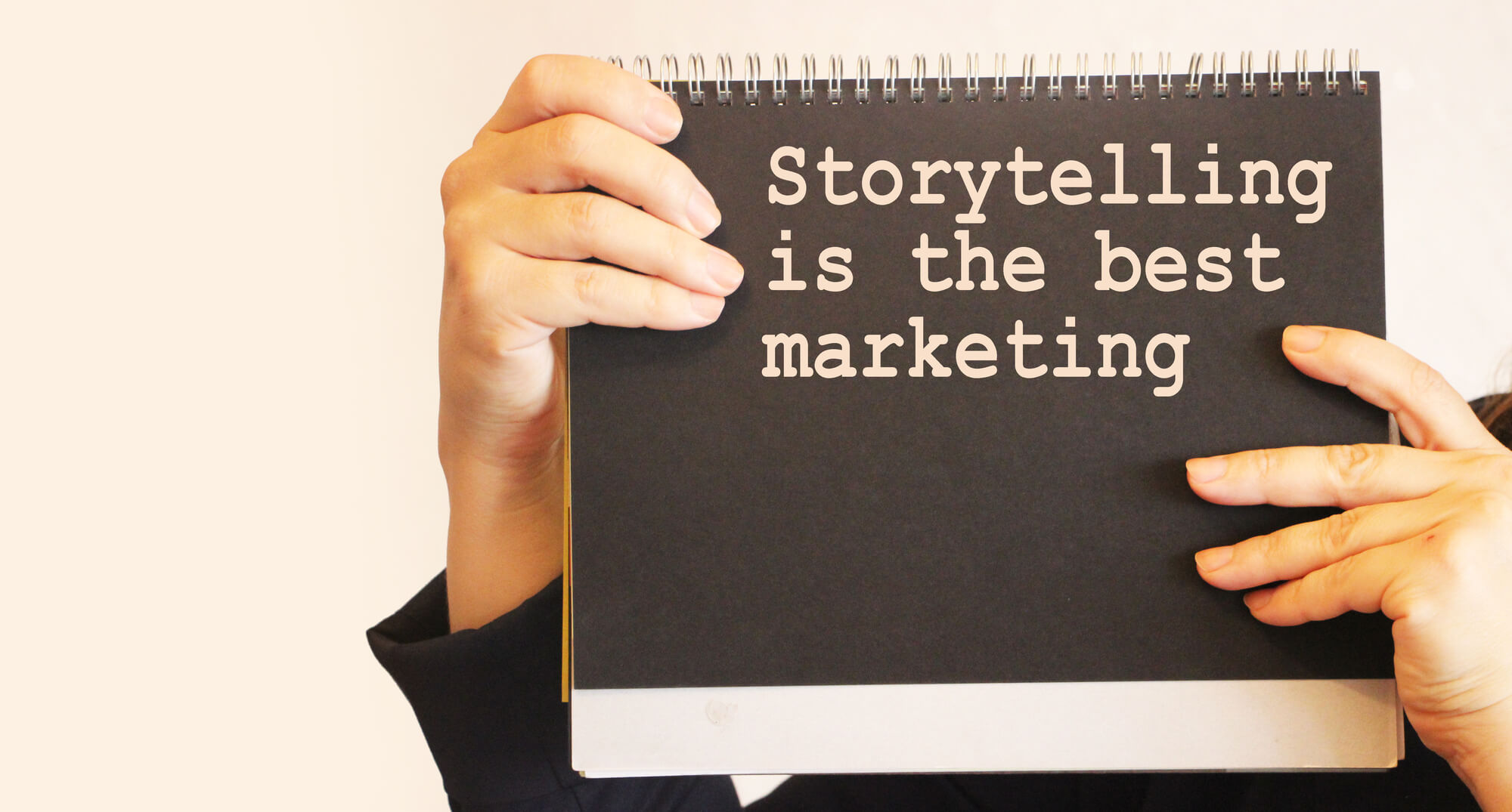 person holding sign saying "storytelling is the best marketing"
