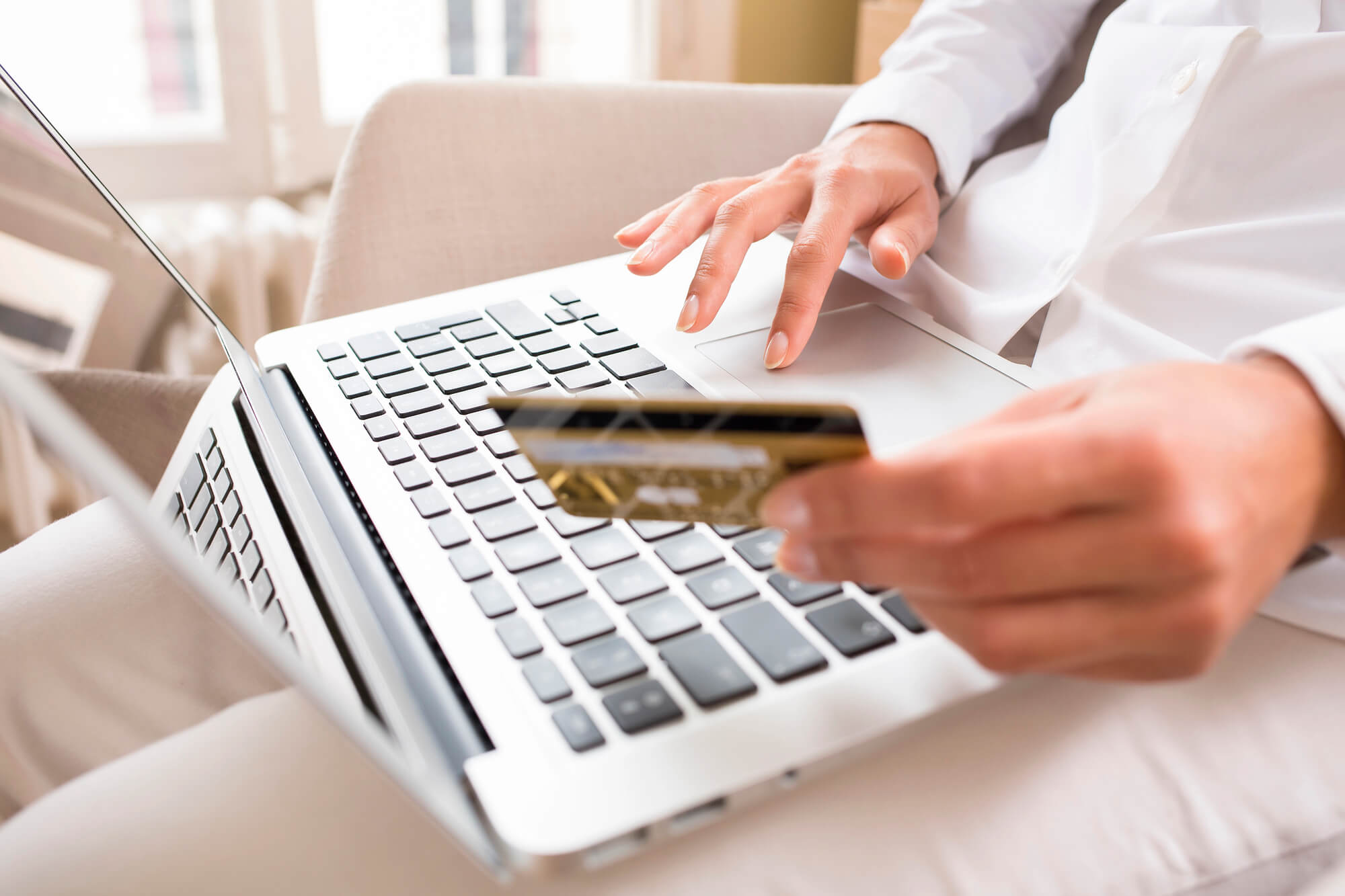 woman typing credit card details on laptop