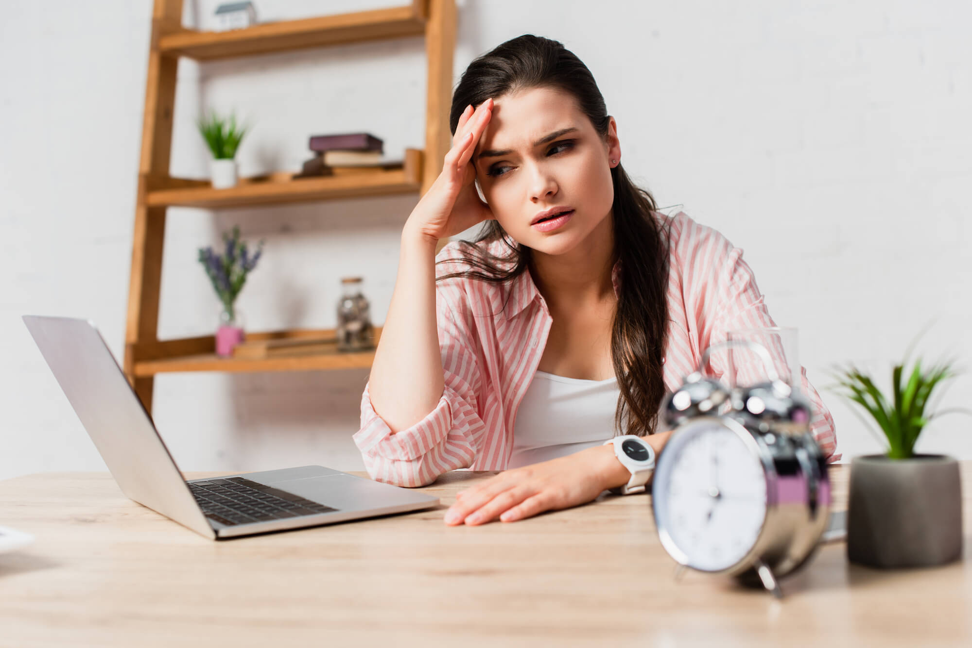 woman looking stressed while working on laptop 