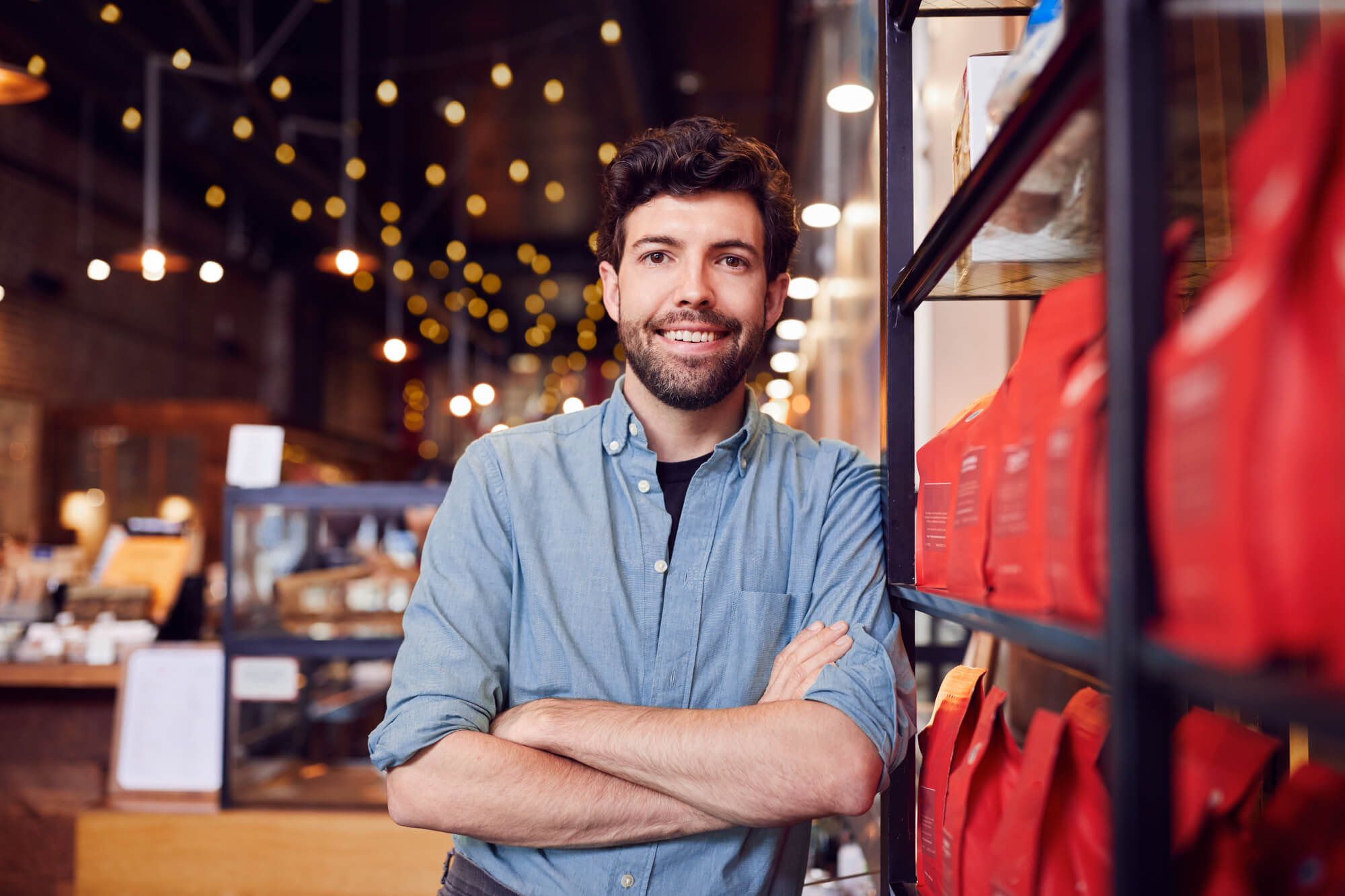 happy cafe owner standing in doorway of his store